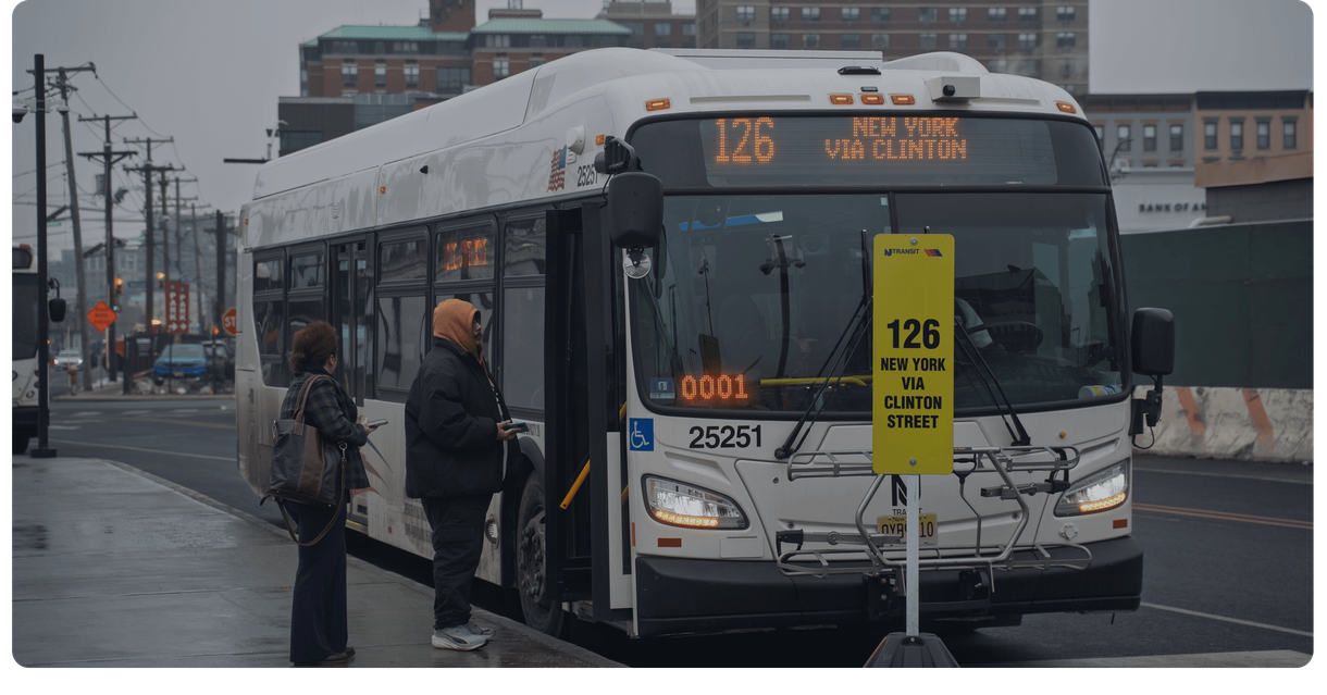 Riders wait to board an NJ TRANSIT bus at a stop