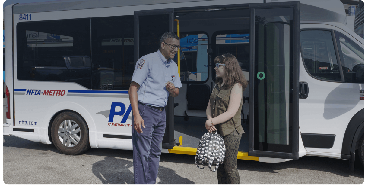 A rider and a driver talk beside an NFTA Metro paratransit van