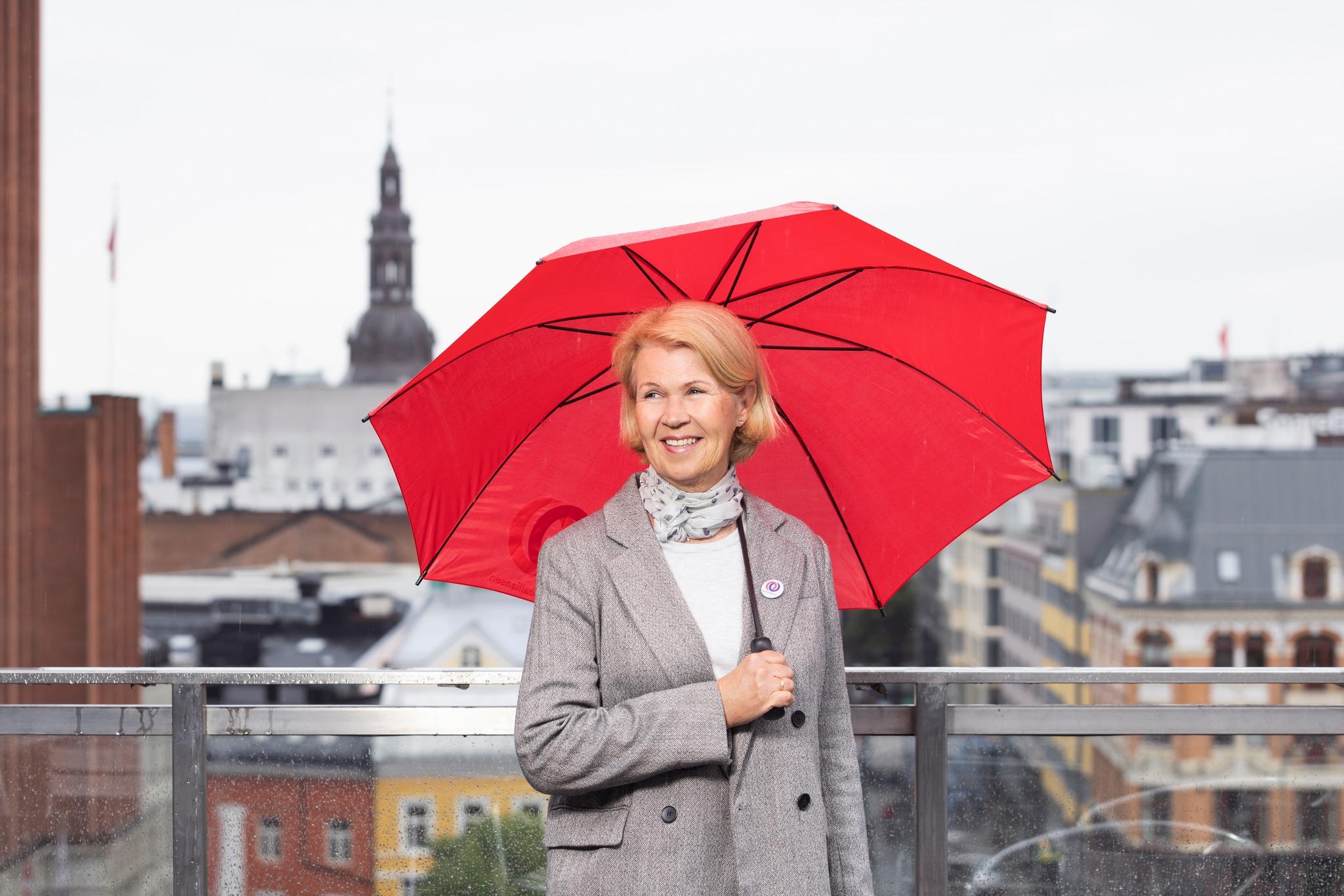 a woman is holding a red umbrella in the rain .