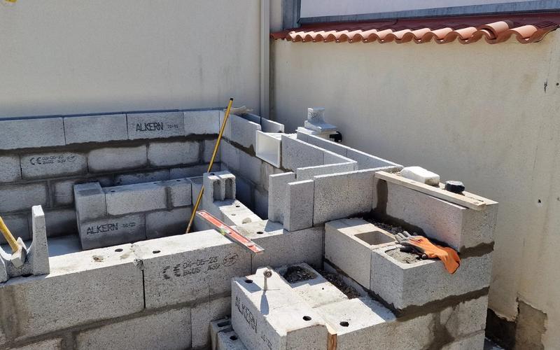 Construction de murs en blocs béton à haute performance sur un chantier résidentiel, maçonnerie conforme à la norme RE 2020