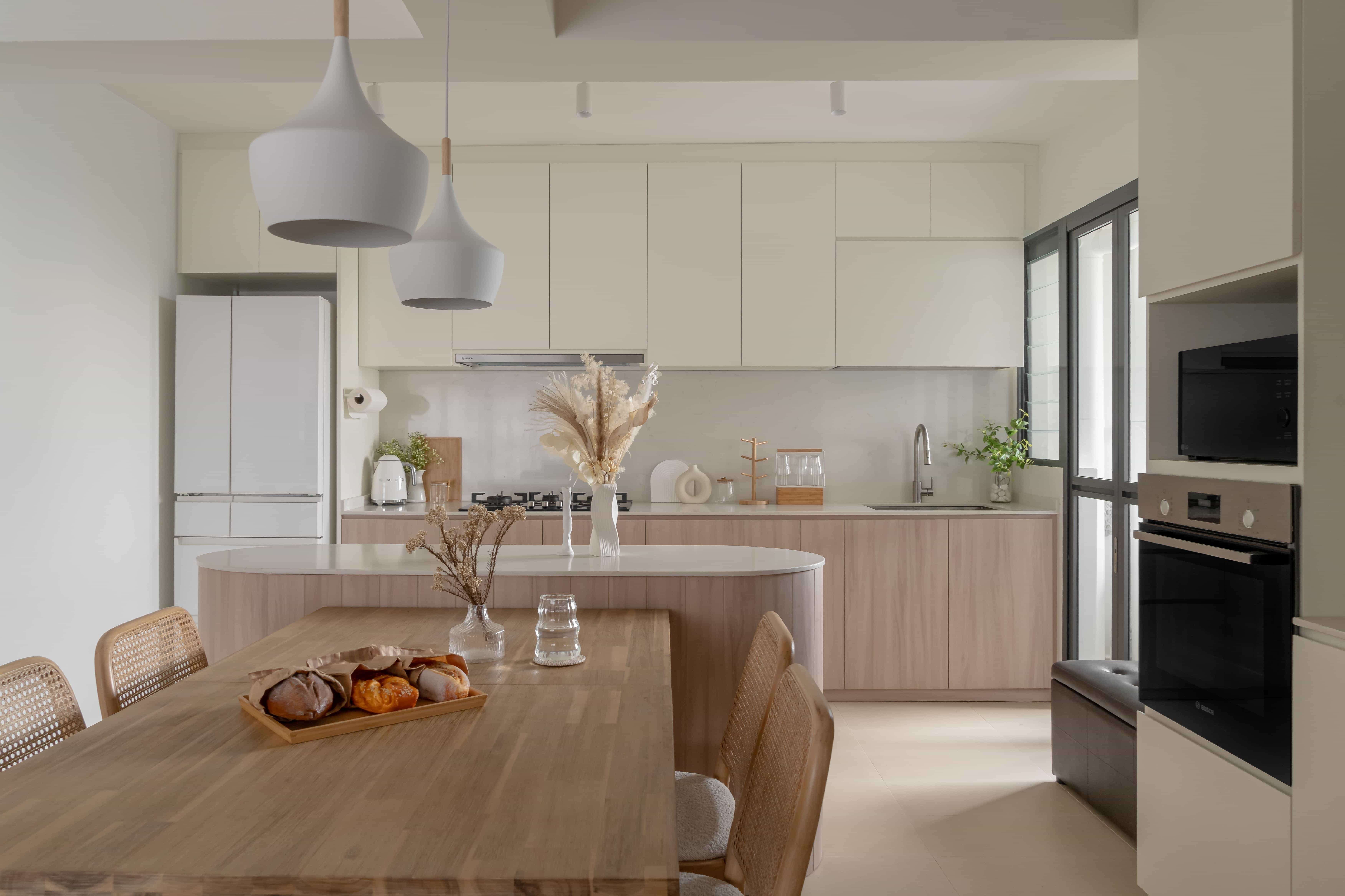 Minimalist HDB kitchen with light cabinets and a natural wood dining table.