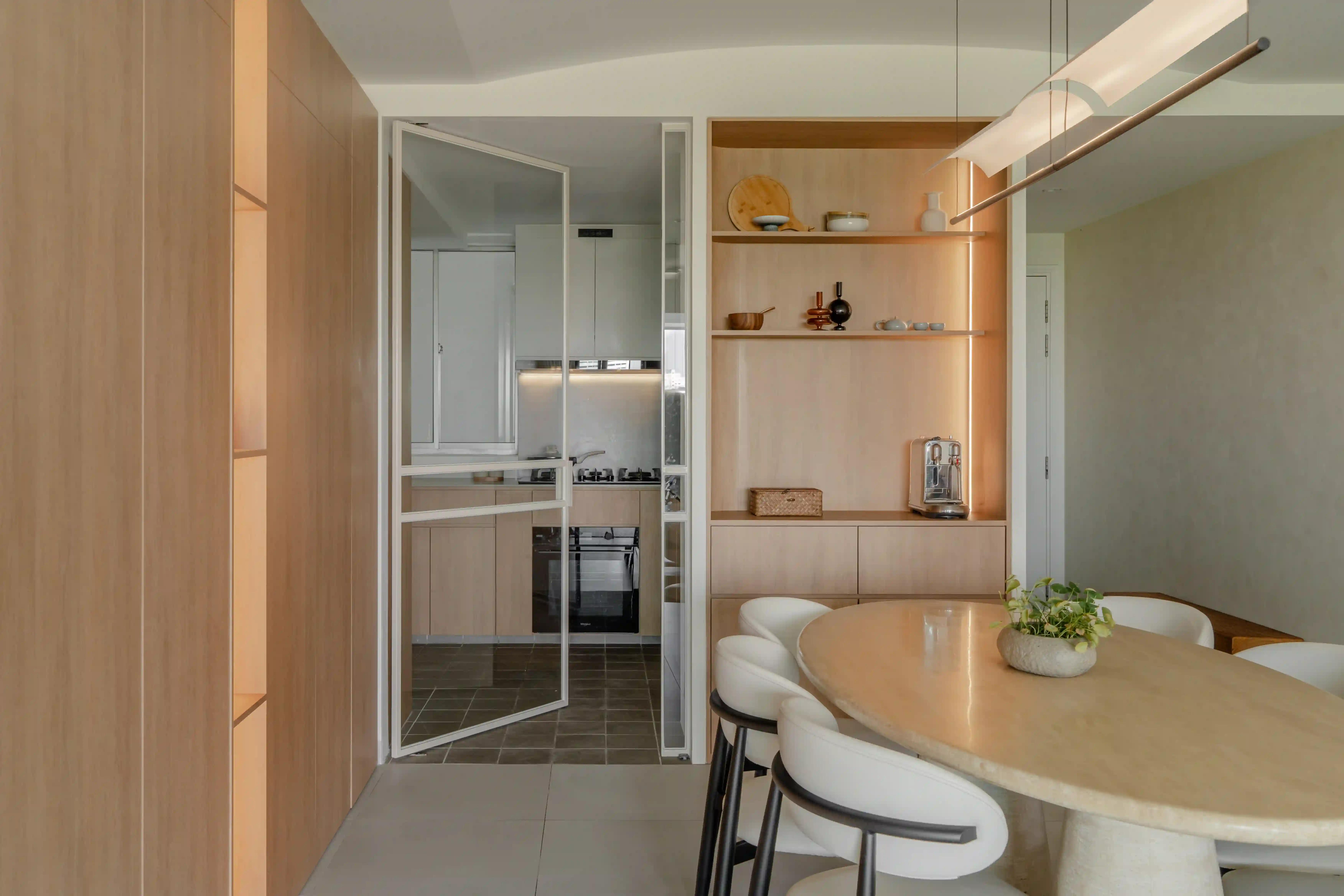 light-wood dining with oval table, open shelves and glass door to kitchen; refined interior decor singapore in a bedok hdb