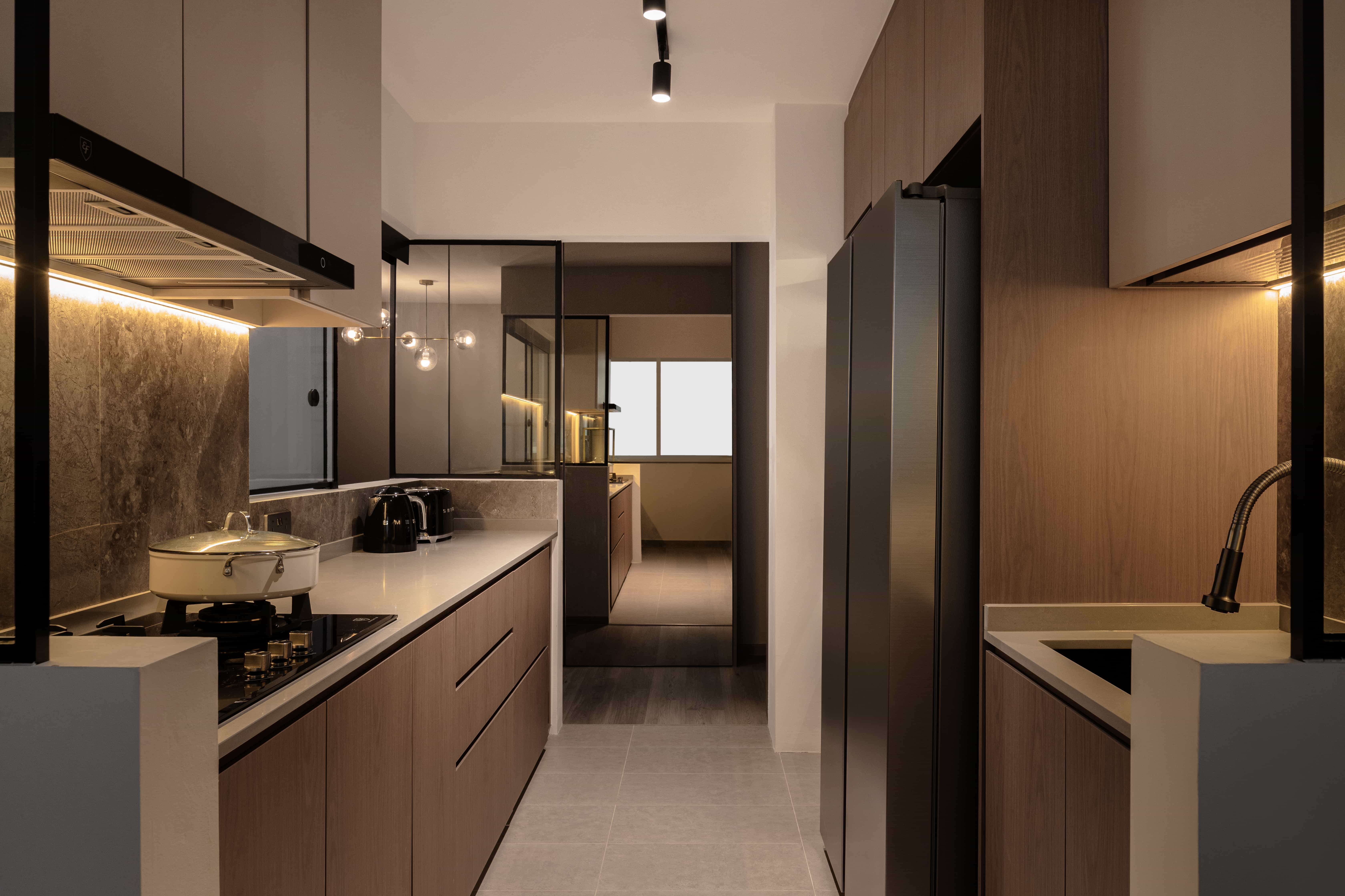 Modern kitchen with sleek cabinetry, built-in appliances, and a reflective backsplash, designed by Rockin Spaces.