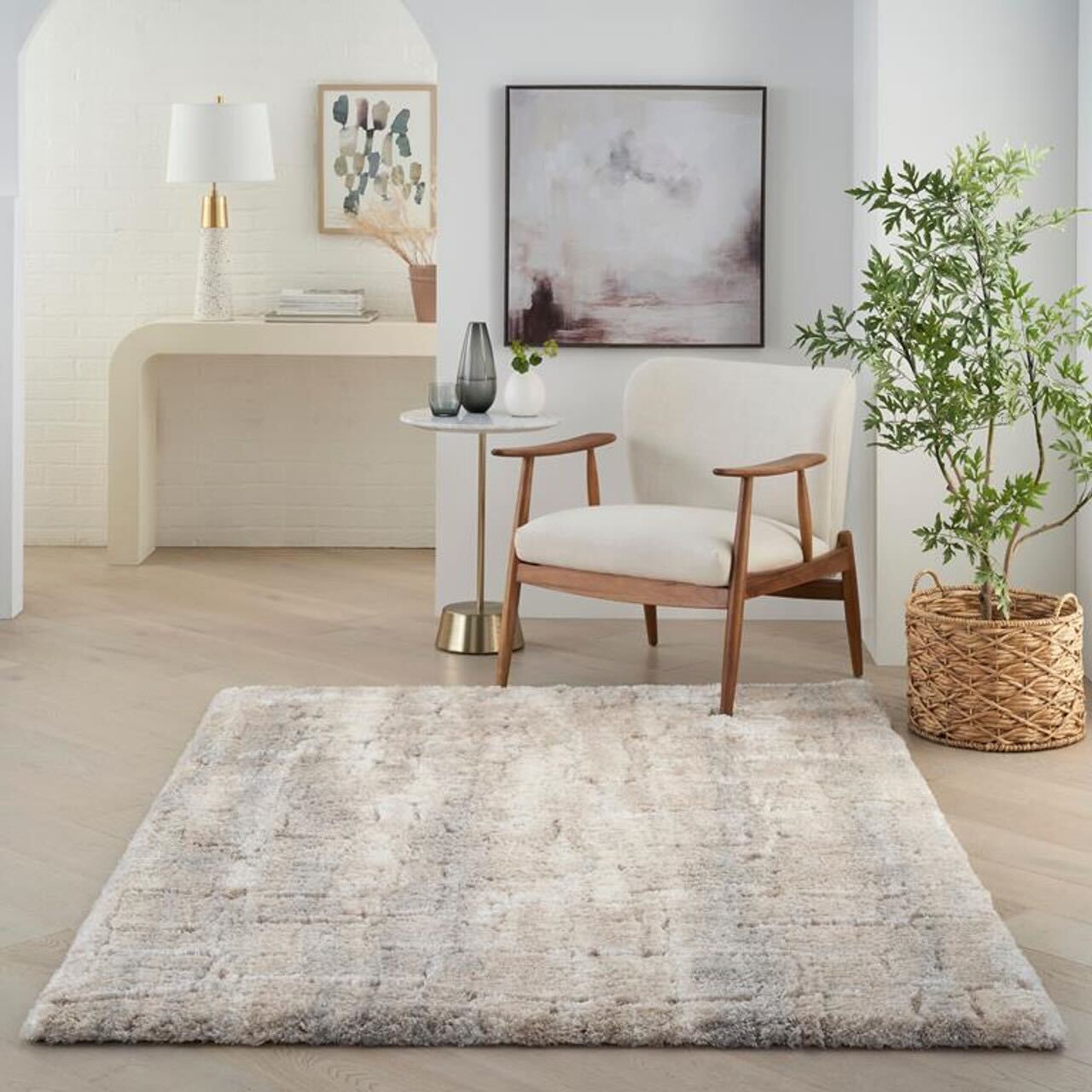 A soft, neutral-toned shag rug in a minimalist living space with a modern chair, small table, and indoor plant.