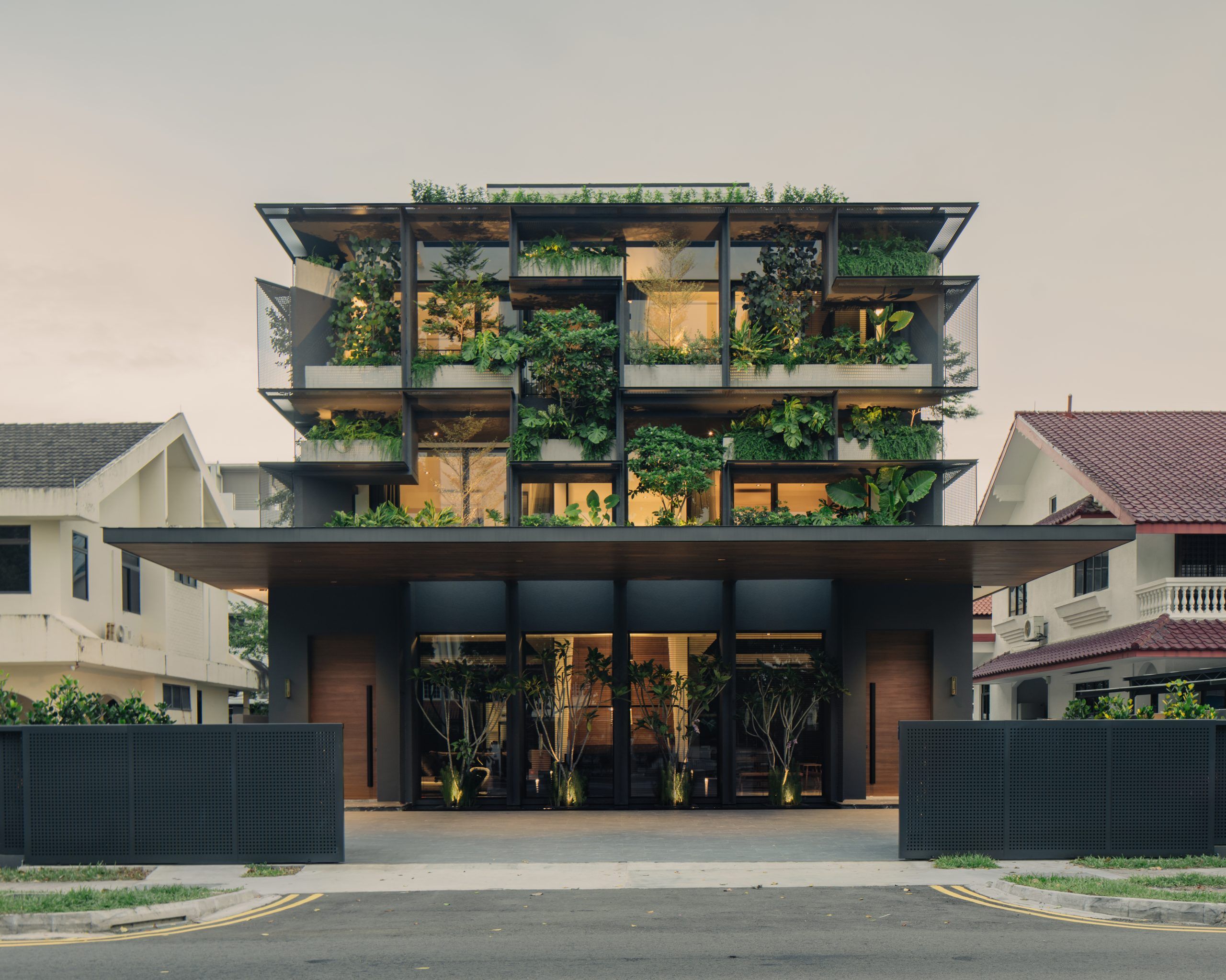 A modern building with lush green plants incorporated into its facade, creating a nature-inspired design.