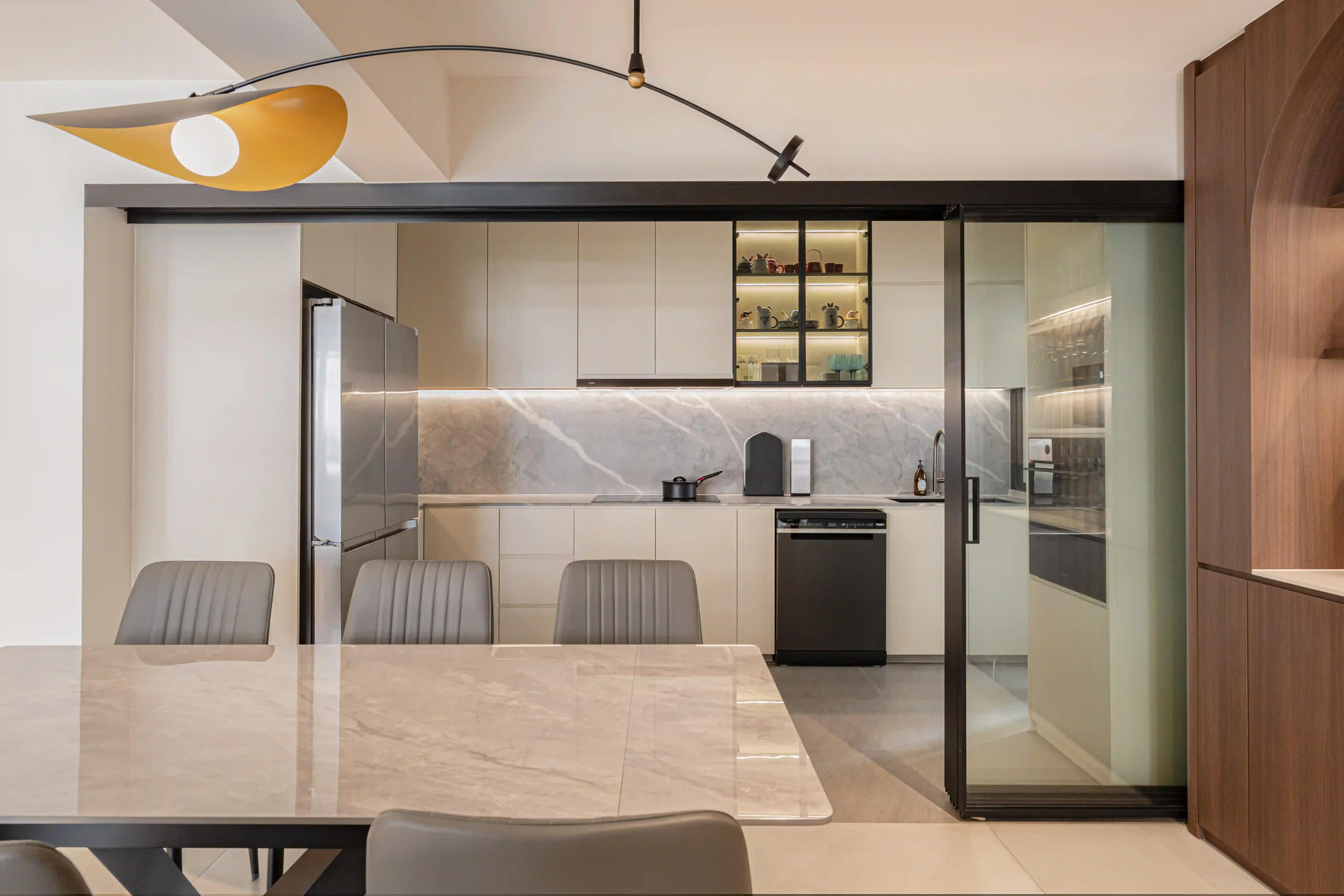 sleek kitchen-dining with marble backsplash, glass partitions and statement pendant; modern interior decor singapore