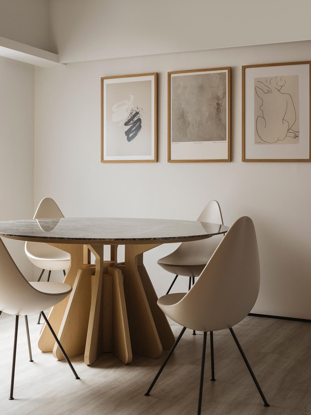 Well-lit dining room featuring a round marble table and white chairs