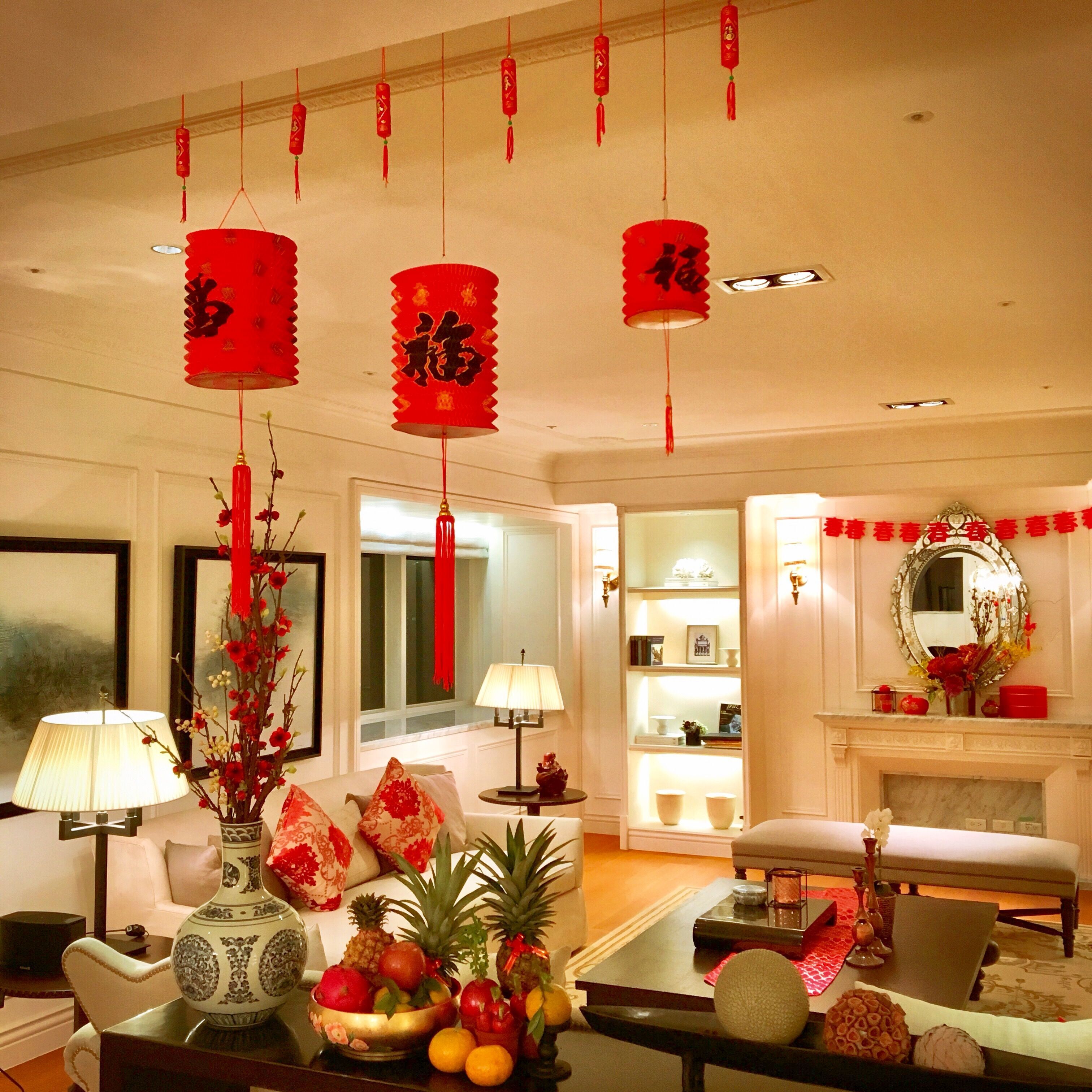 Festive living room with red lanterns, pineapple offerings, and Chinese New Year decorations.