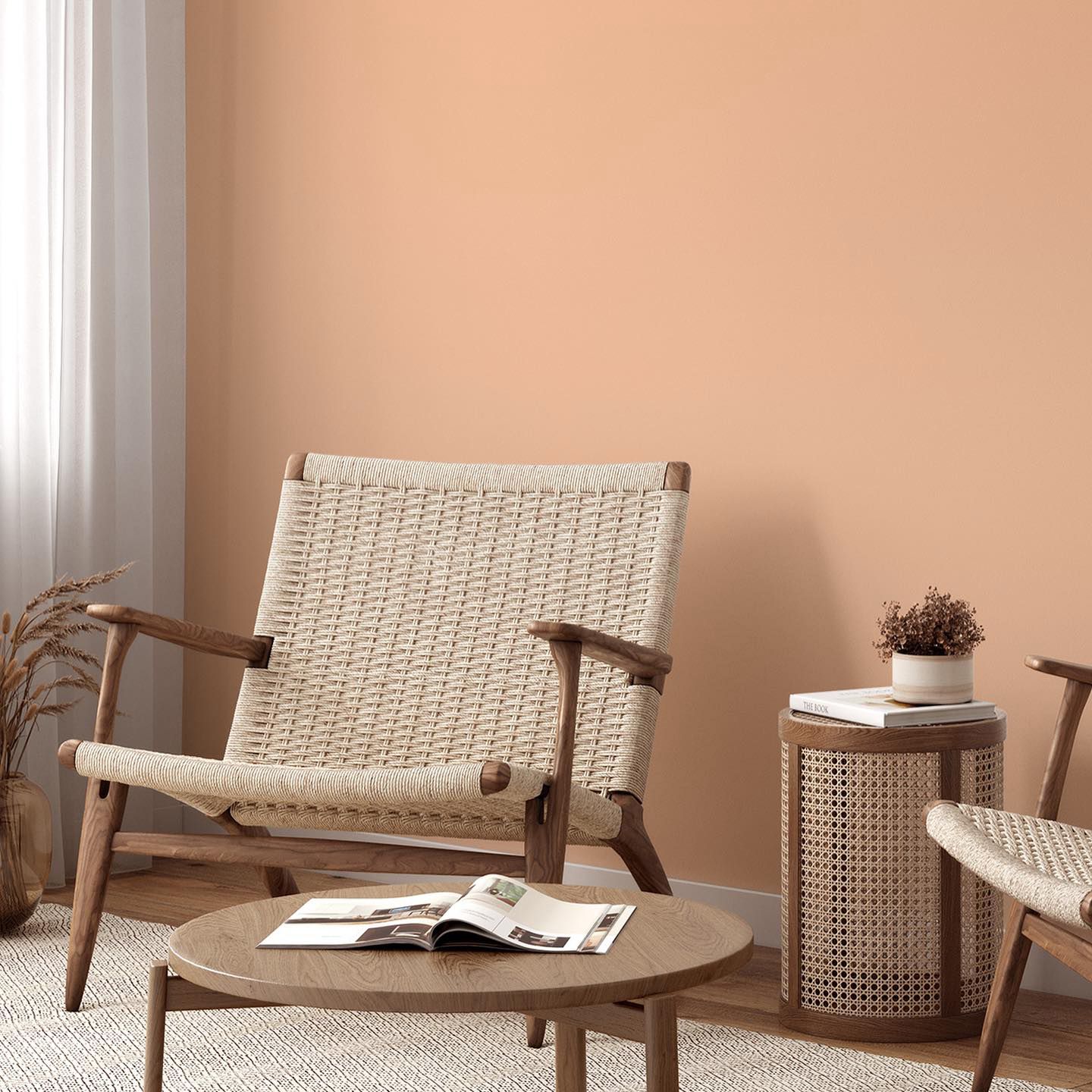 Cozy interior design with Peach Fuzz colored walls, a woven rattan armchair, and a wooden side table, showcasing Nippon Paint's Autumn Lights in a modern home