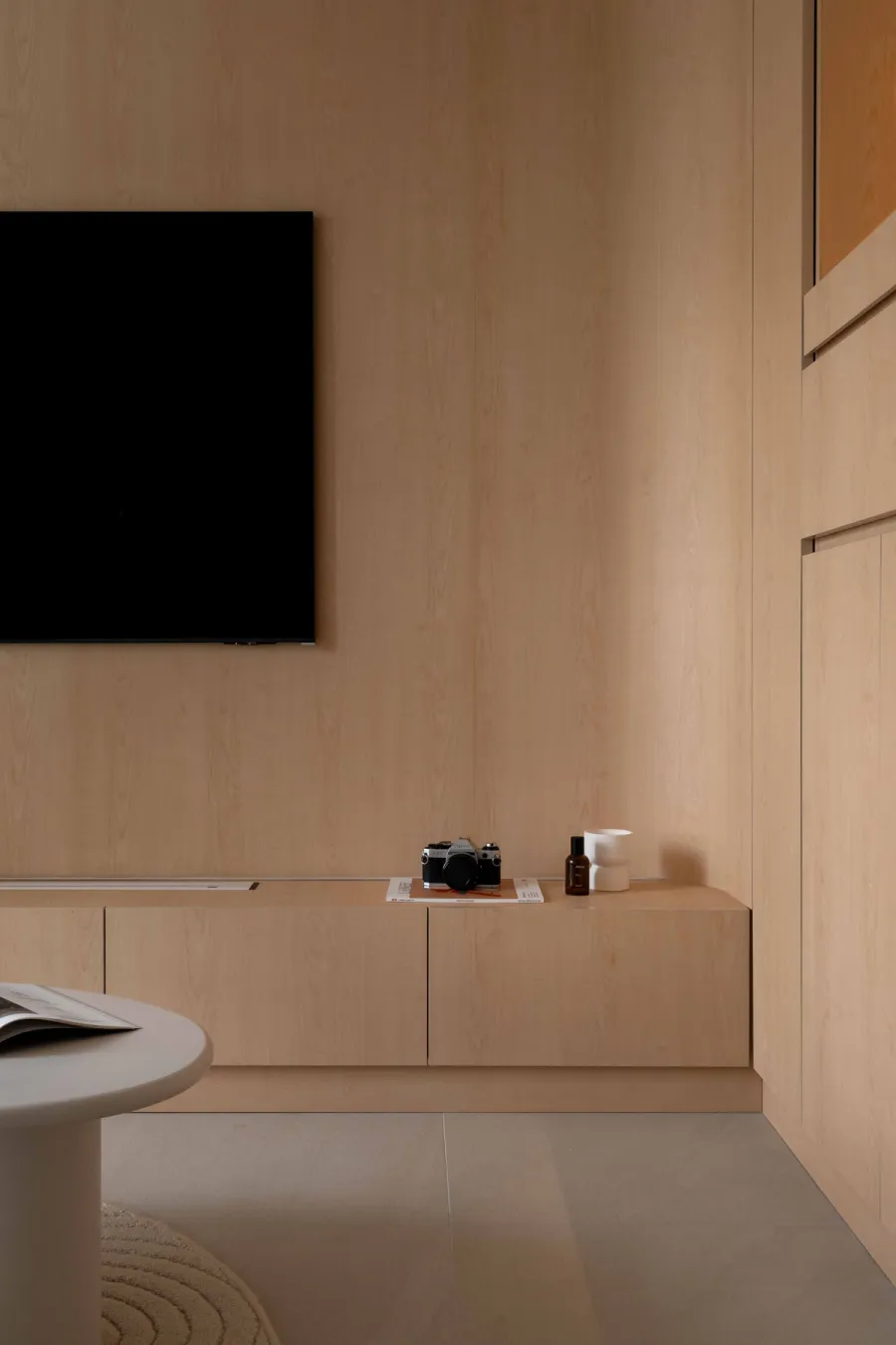 Seamless floor to ceiling tv wall in warm wood and curved edges