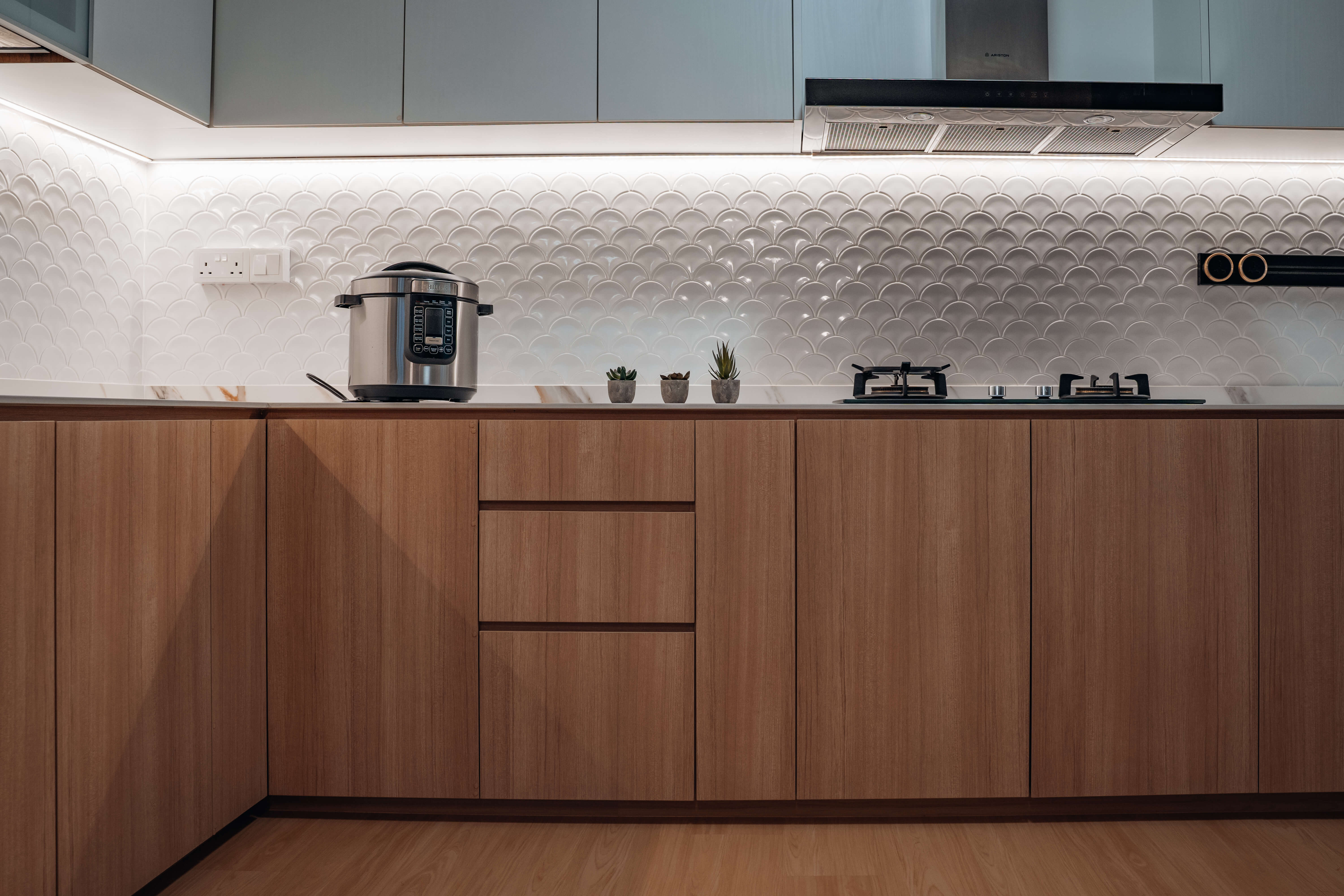 Scandinavian kitchen with wooden cabinets, white backsplash, and modern appliances.