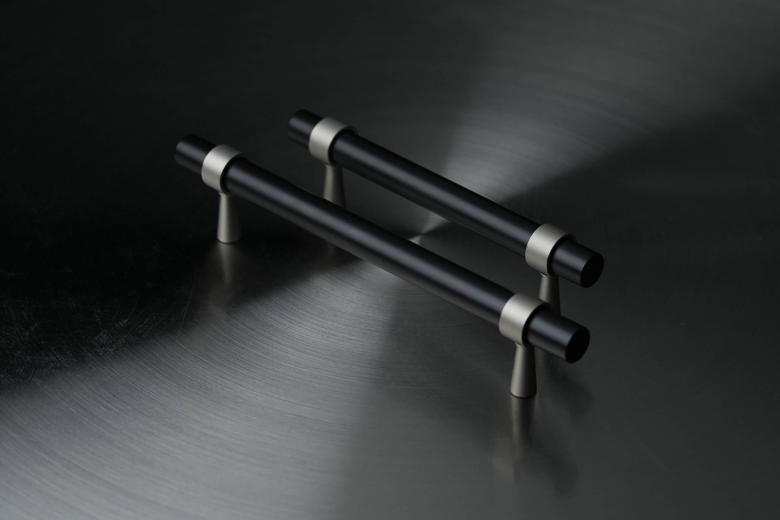 Sleek and modern metallic cabinet handles against a dark background, reflecting contemporary design aesthetics and the integration of the Metal element in Feng Shui for a clear and precise home ambiance