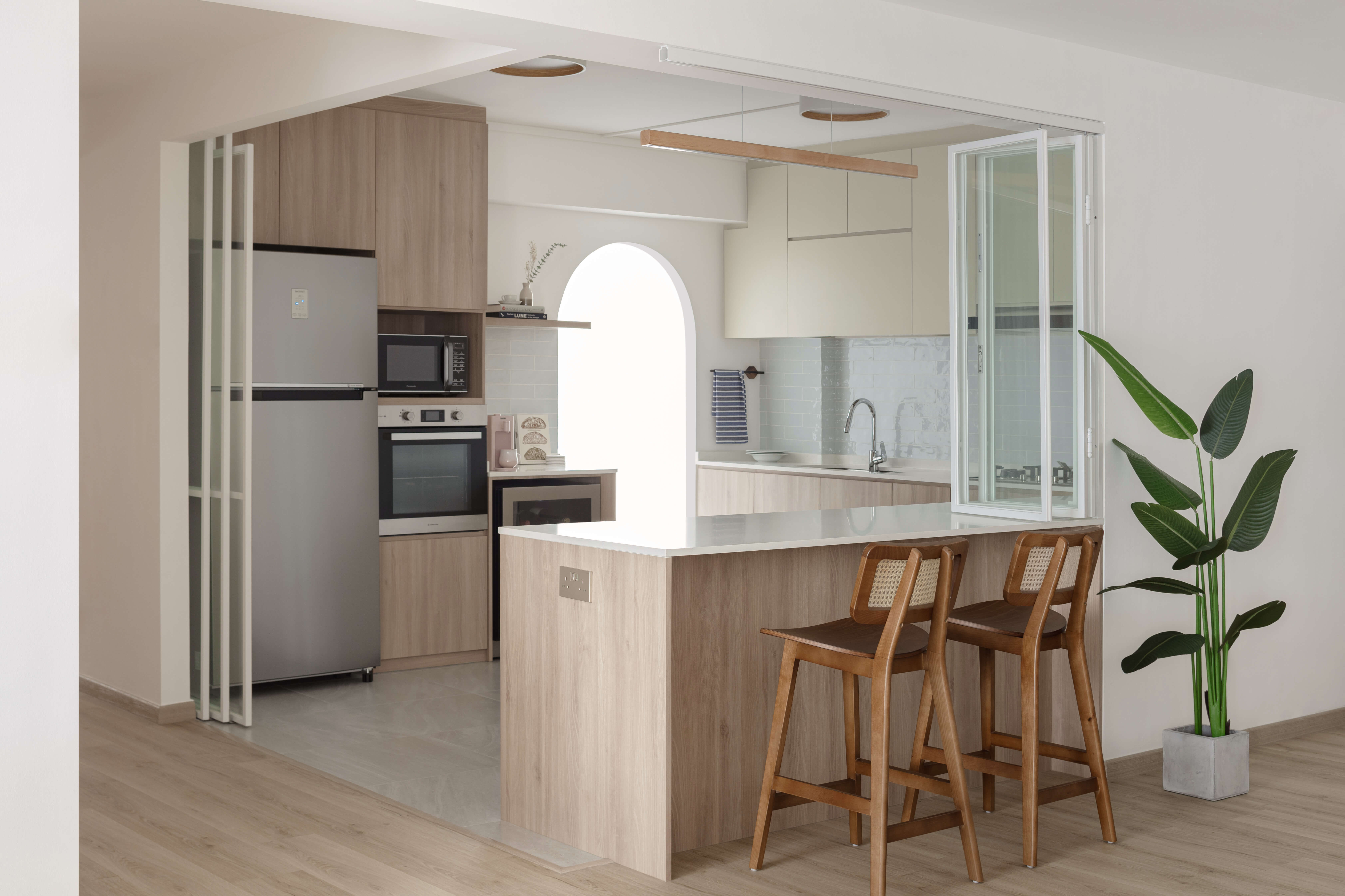 HDB kitchen with light wood cabinetry and island counter with bar stools.