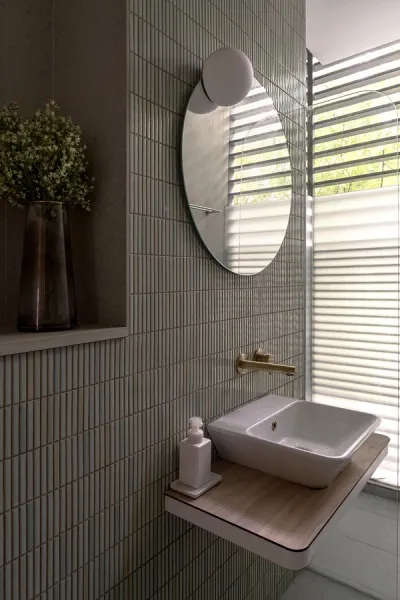 Sink area with tiled walls, mounted round mirror, gold hardware, white porcelain and wooden elements