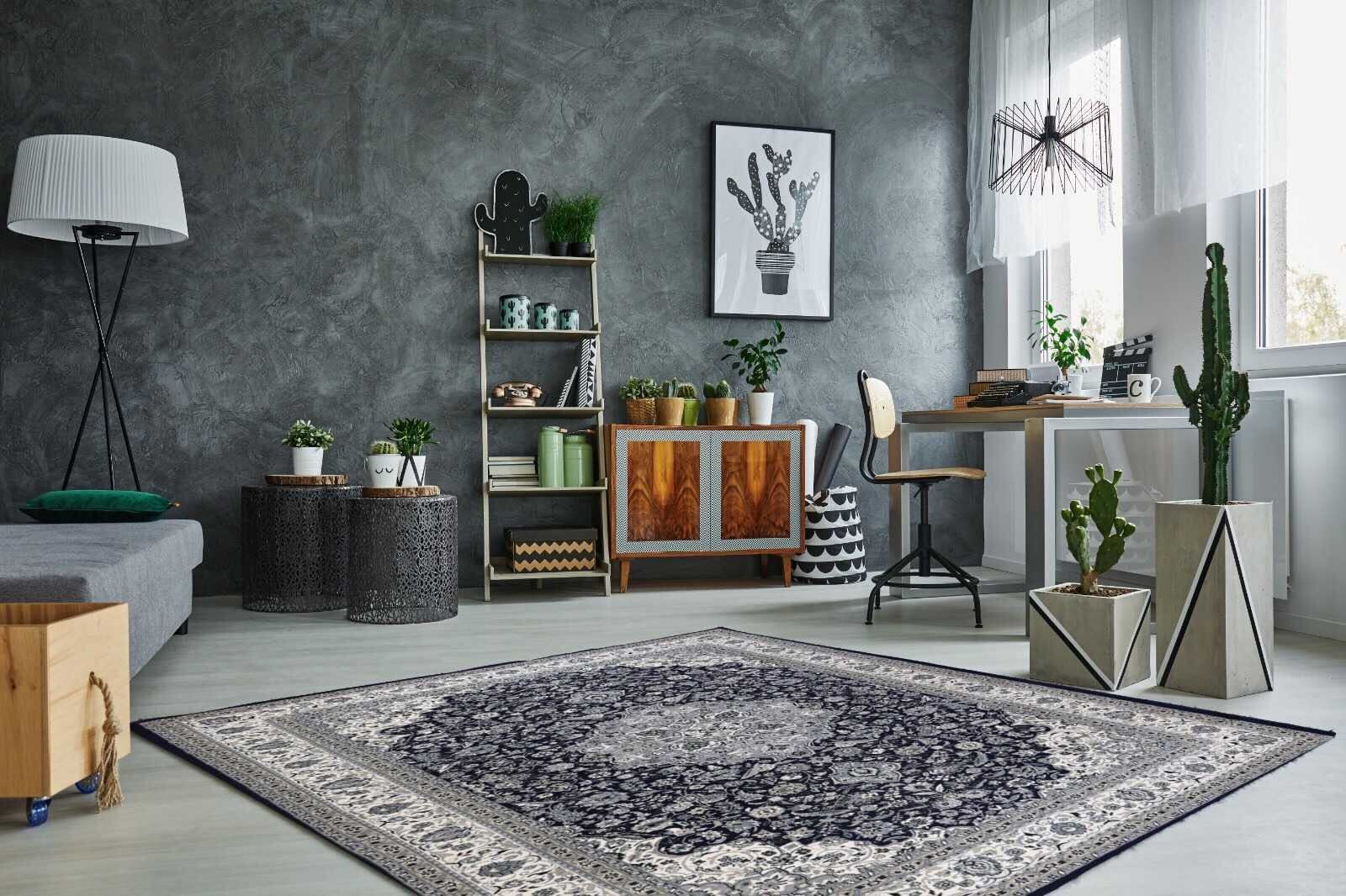 A Persian rug with intricate patterns in a modern home office with dark walls, plants, and wooden accents.