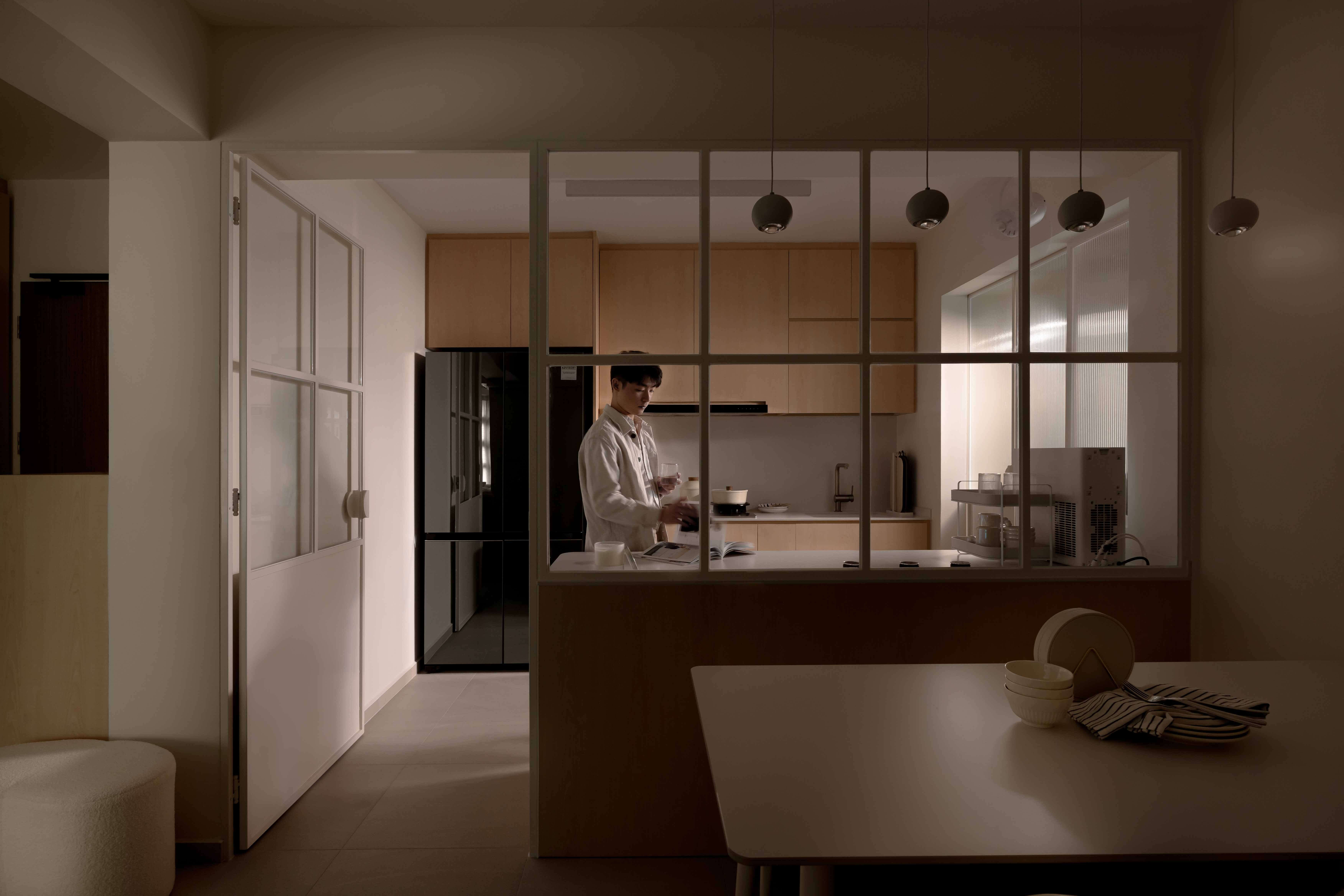 Compact HDB kitchen with a glass divider and warm ambient lighting.