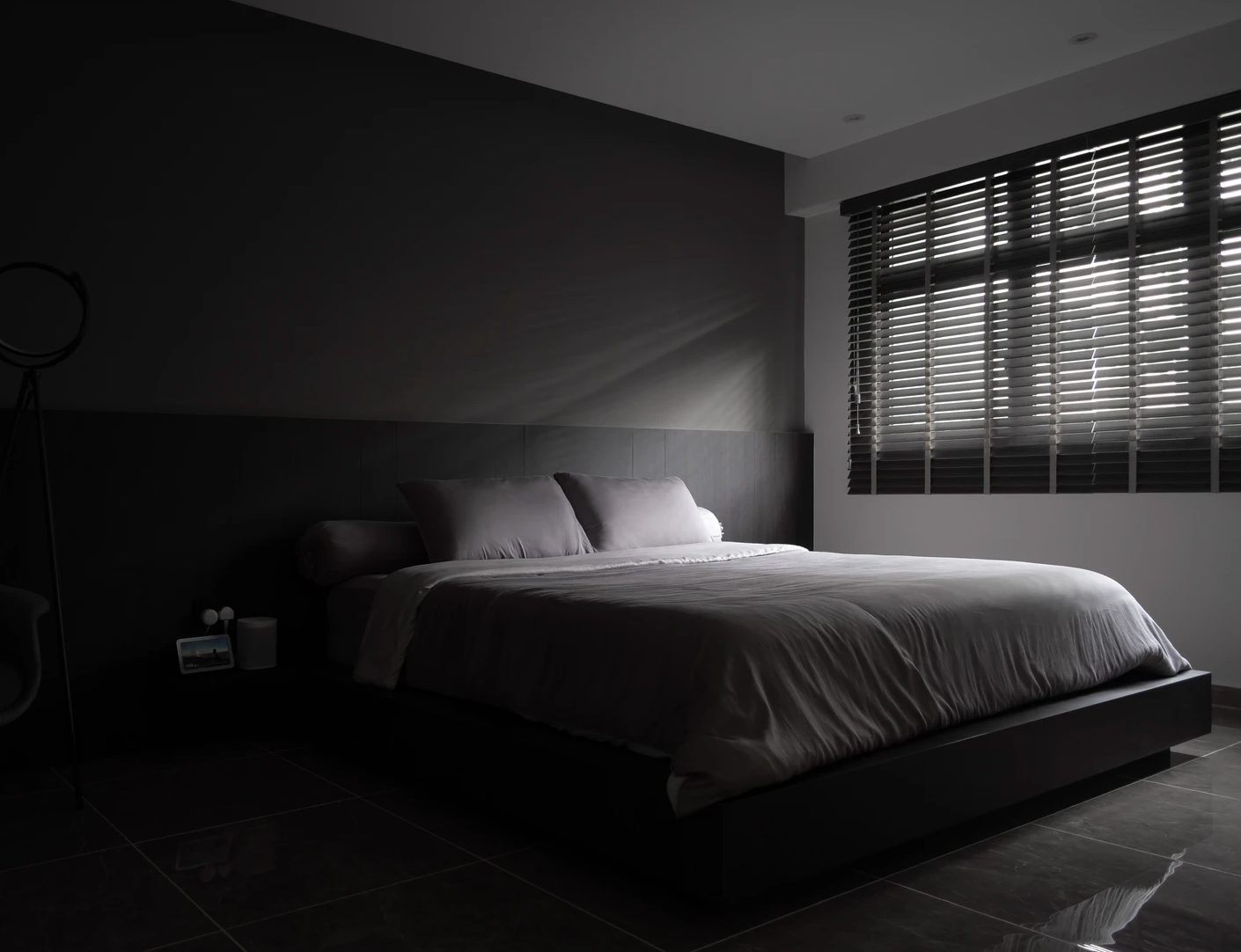 Minimalist bedroom with a sleek bed frame with light and dark colour palette