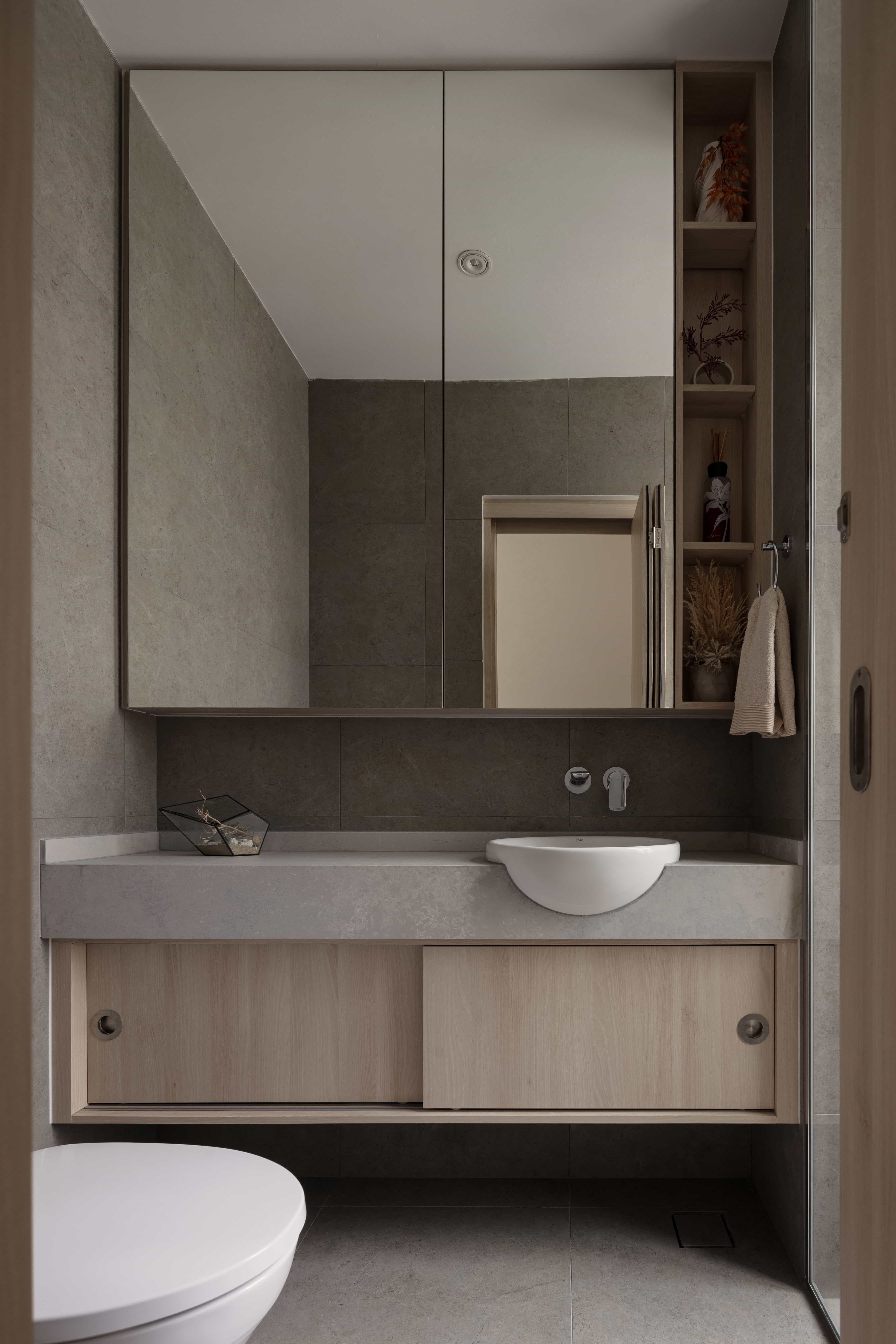 Compact bathroom with large mirrored cabinets and an integrated sink vanity unit.