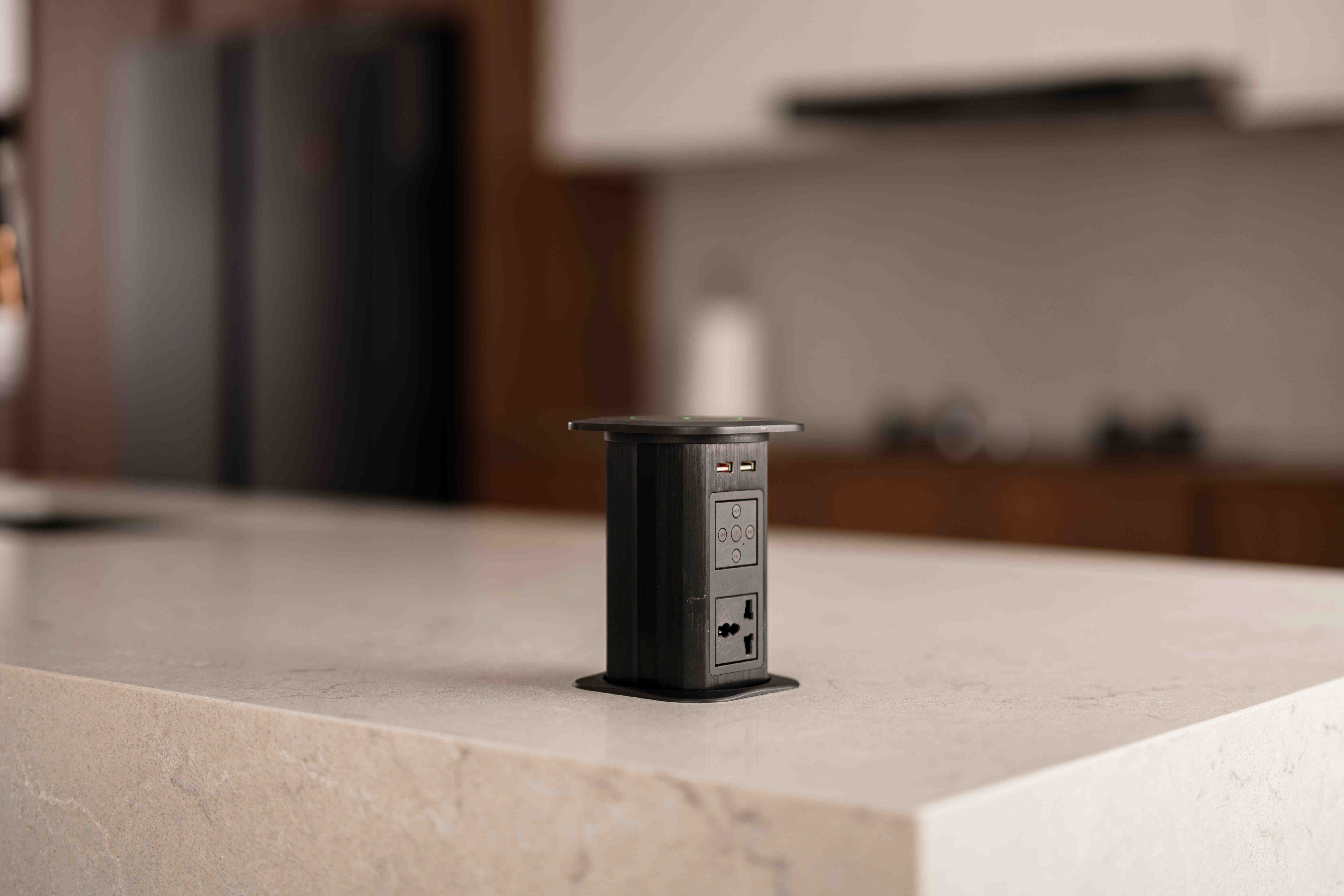 Pop-up smart home power outlet recessed in a quartz kitchen island for clutter-free charging