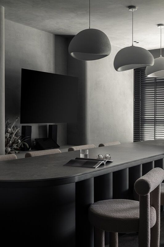 Simple minimalistic interior with dark grey hues and soft curved pieces of furniture