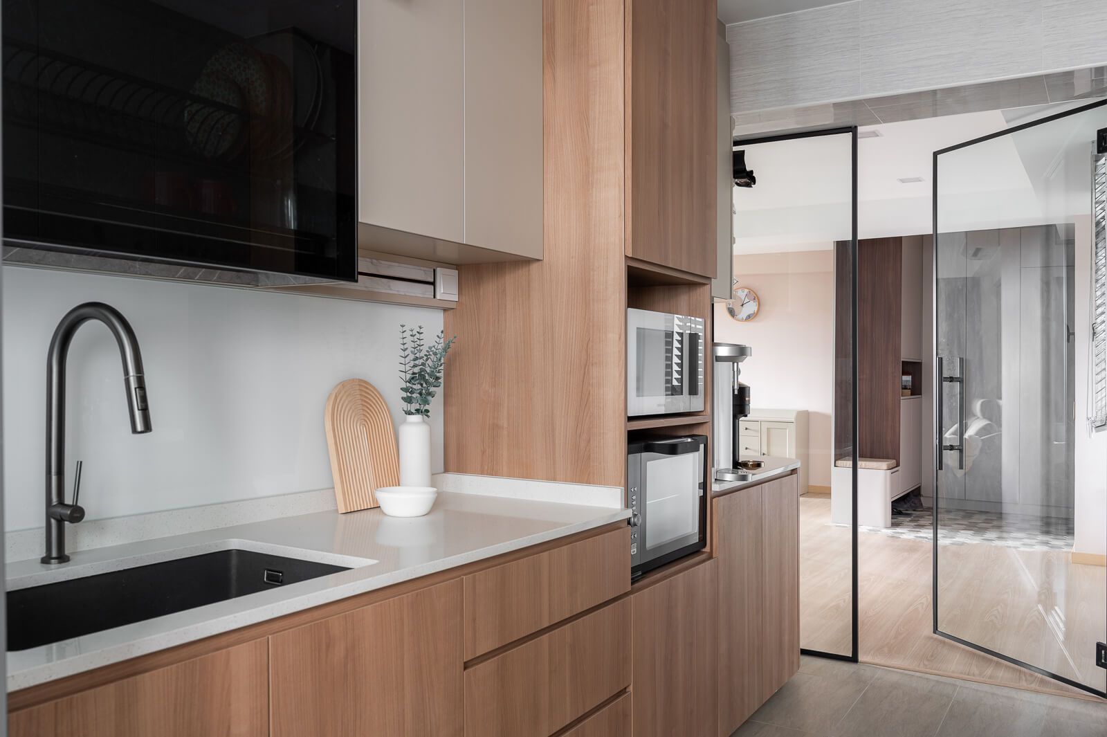 Sleek Scandinavian kitchen design with wooden cabinets, modern appliances, and glass partition.