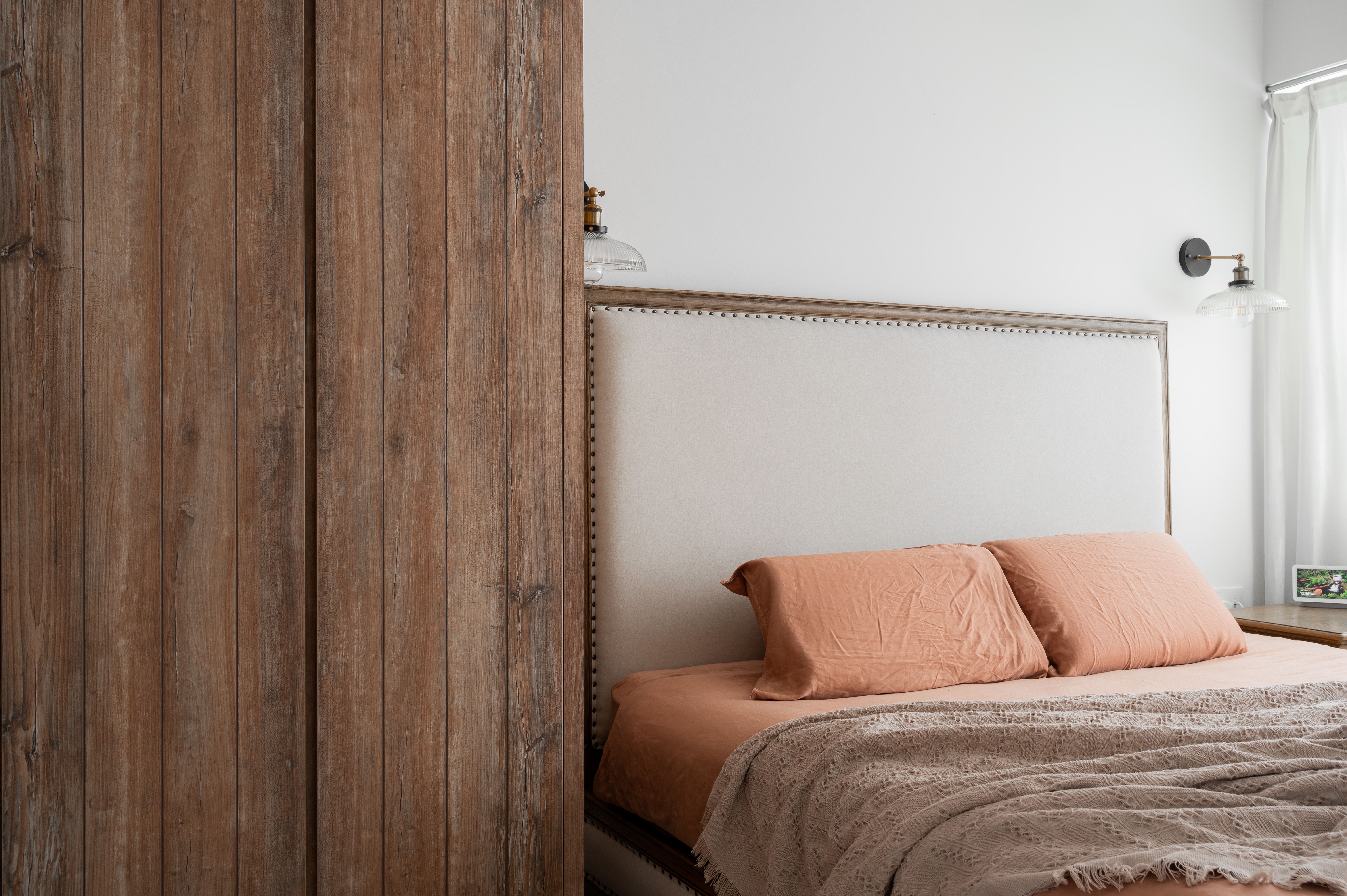 Modern Rustic Bedroom with Wooden Walls, Cozy Bed, White Closet Door, and Wooden Floor.