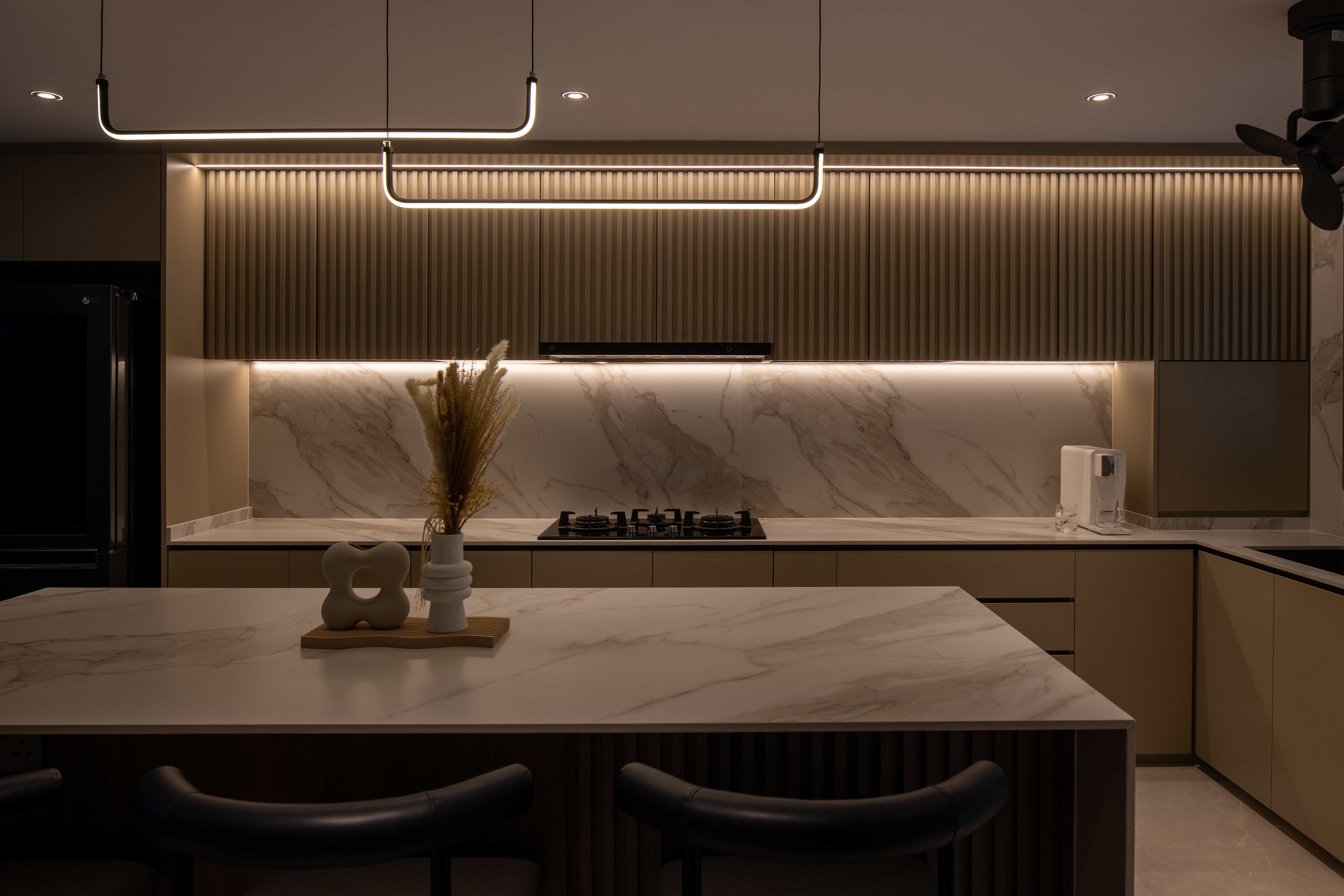 Stylish kitchen featuring marble countertops, under-cabinet lighting, and a large kitchen island, designed by Lemonfridge.