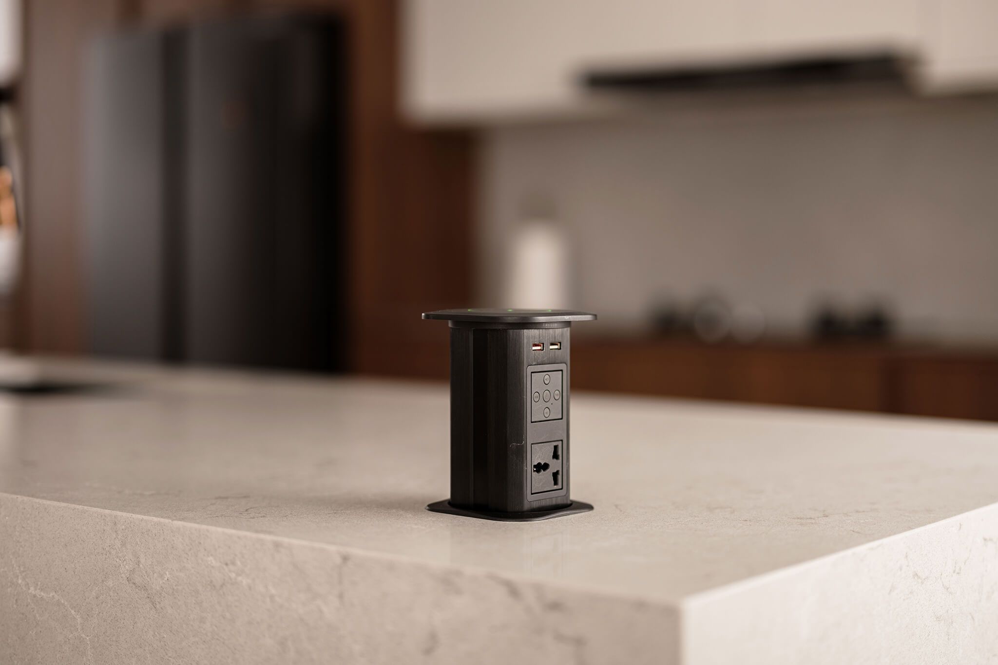 Pop-up electrical outlet on a marble kitchen island countertop providing convenient power access for modern kitchen appliances in a sleek design.