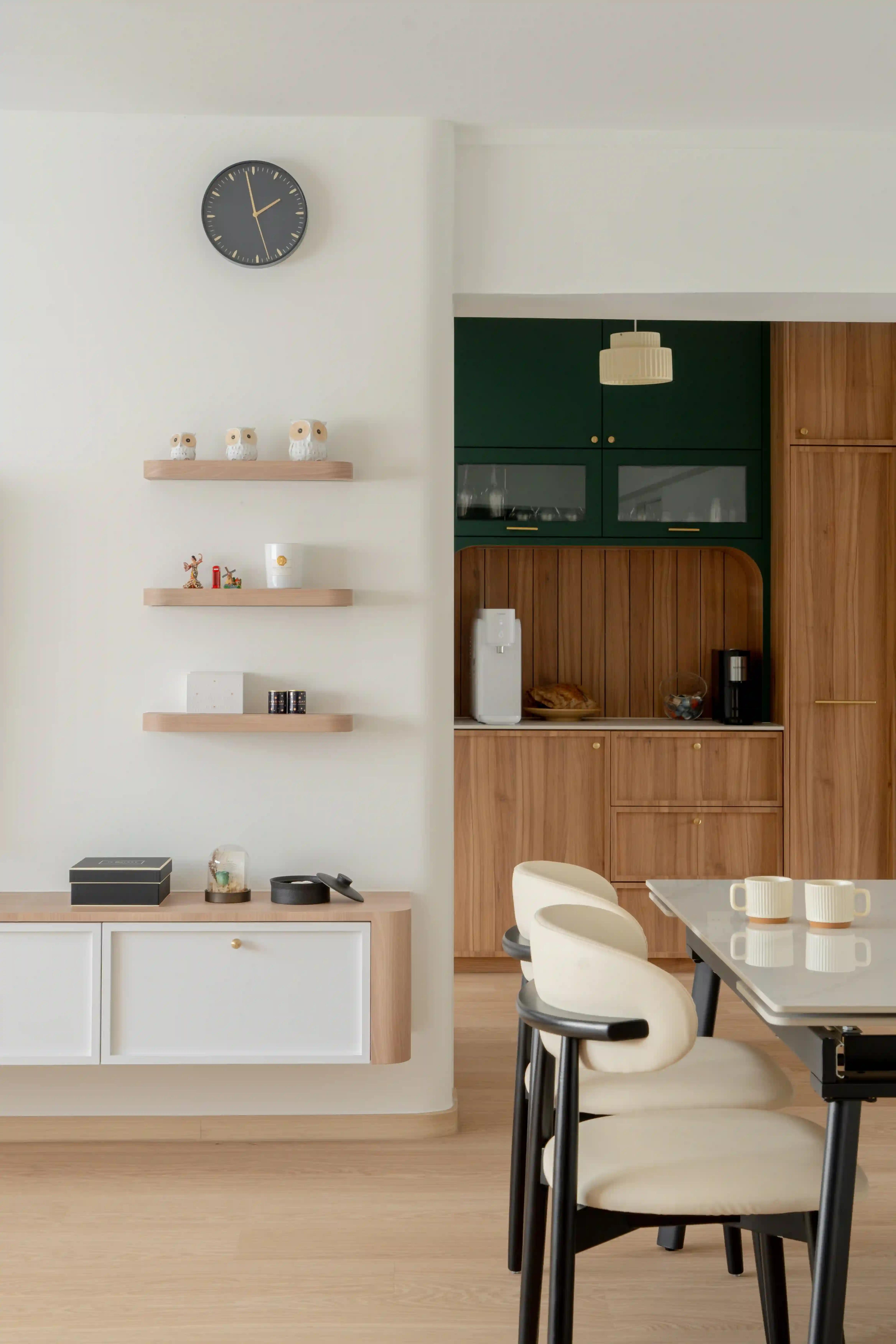 Scandinavian home interior design dining area with floating shelves and view to wood-and-green kitchen cabinetry.