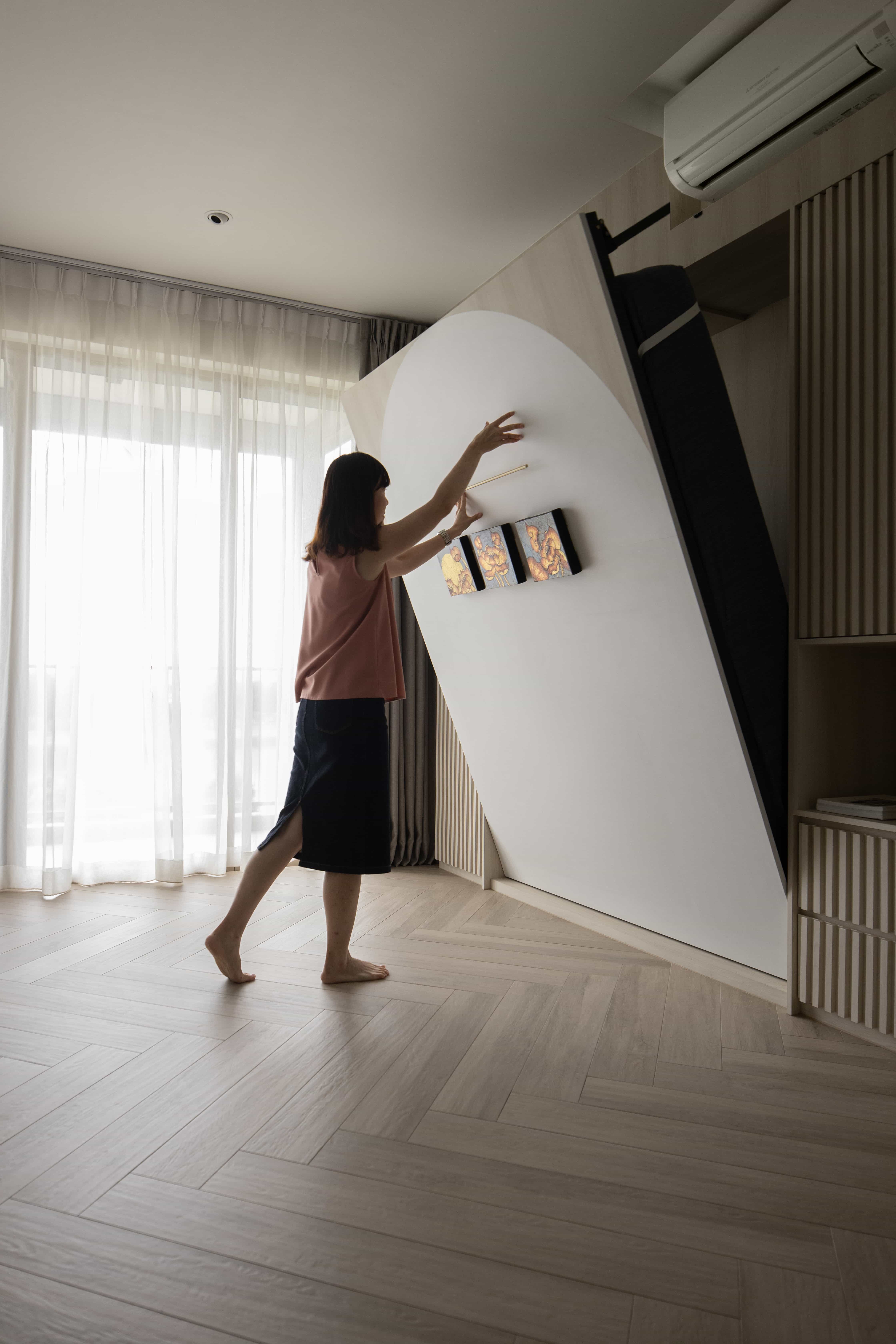 Small bedroom with a DIY Murphy bed being folded up to save space.