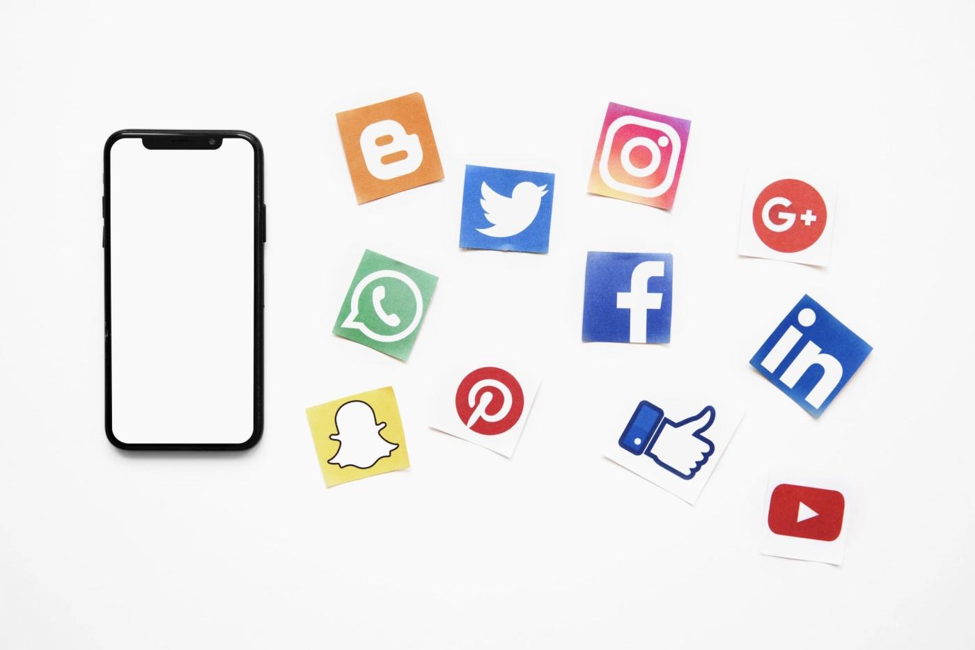 smartphone-with-blank-white-screen-besides-vivid-social-media-icons