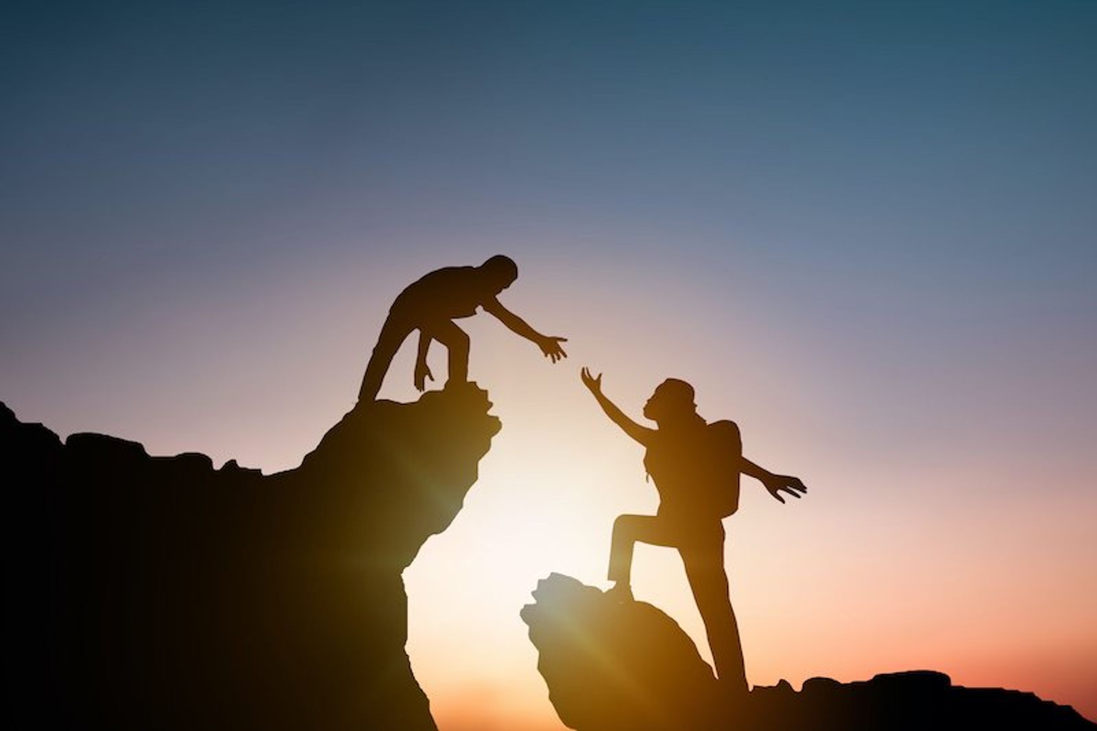 A leader reaching out to help someone climb up