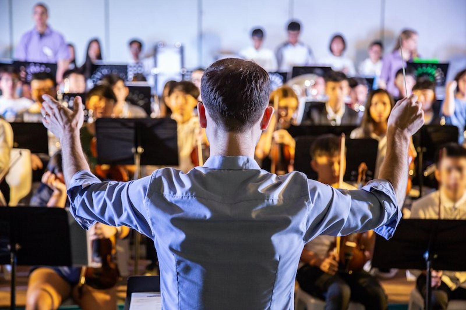 A conductor and orchestra getting ready to perform