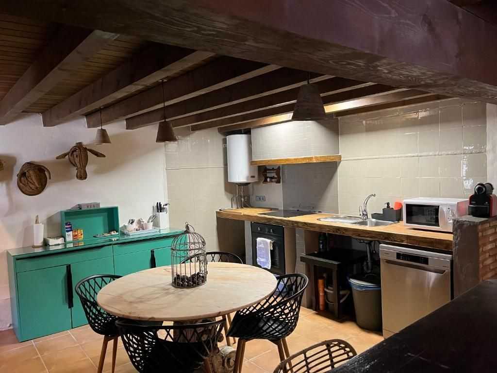 Cocina completa con mesa de comedor y aparador verde