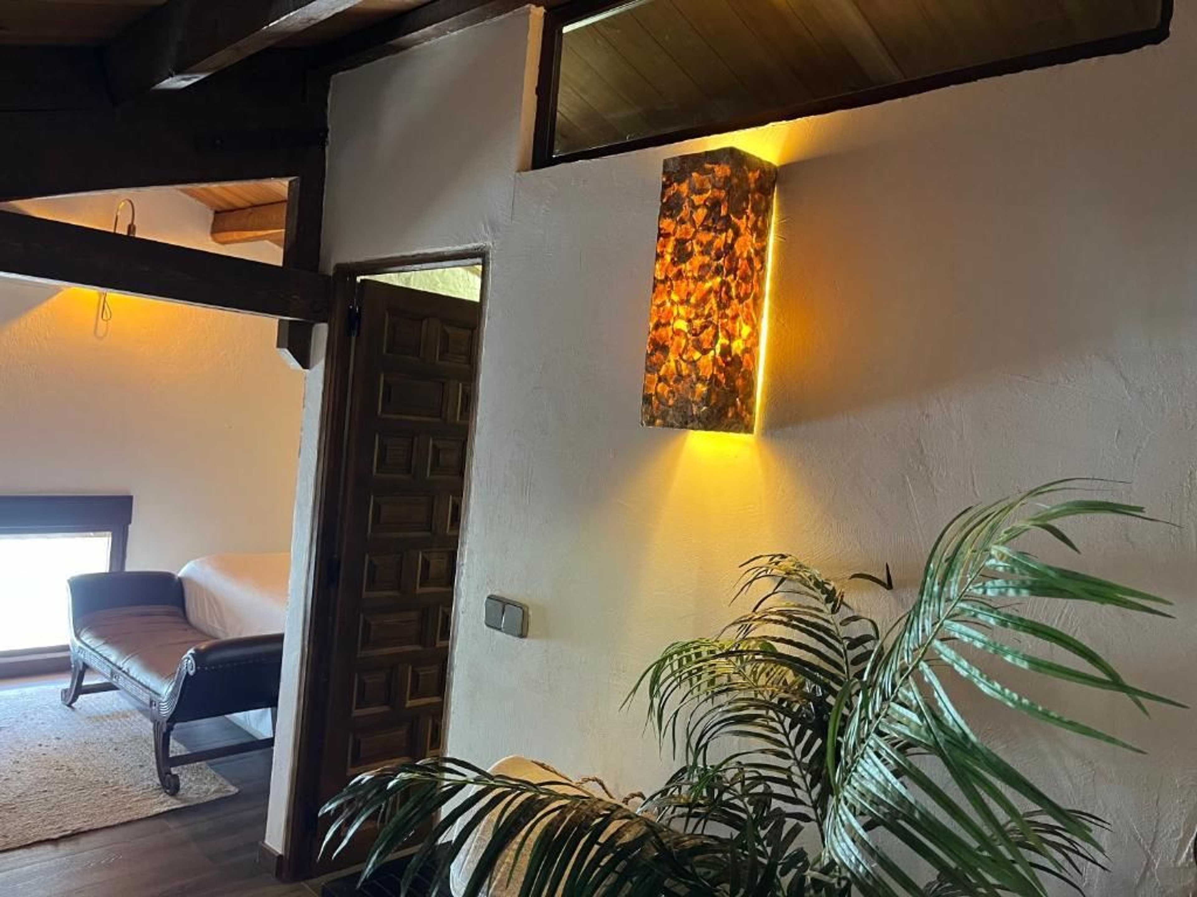 Pasillo del altillo con aplique ámbar y puerta del dormitorio