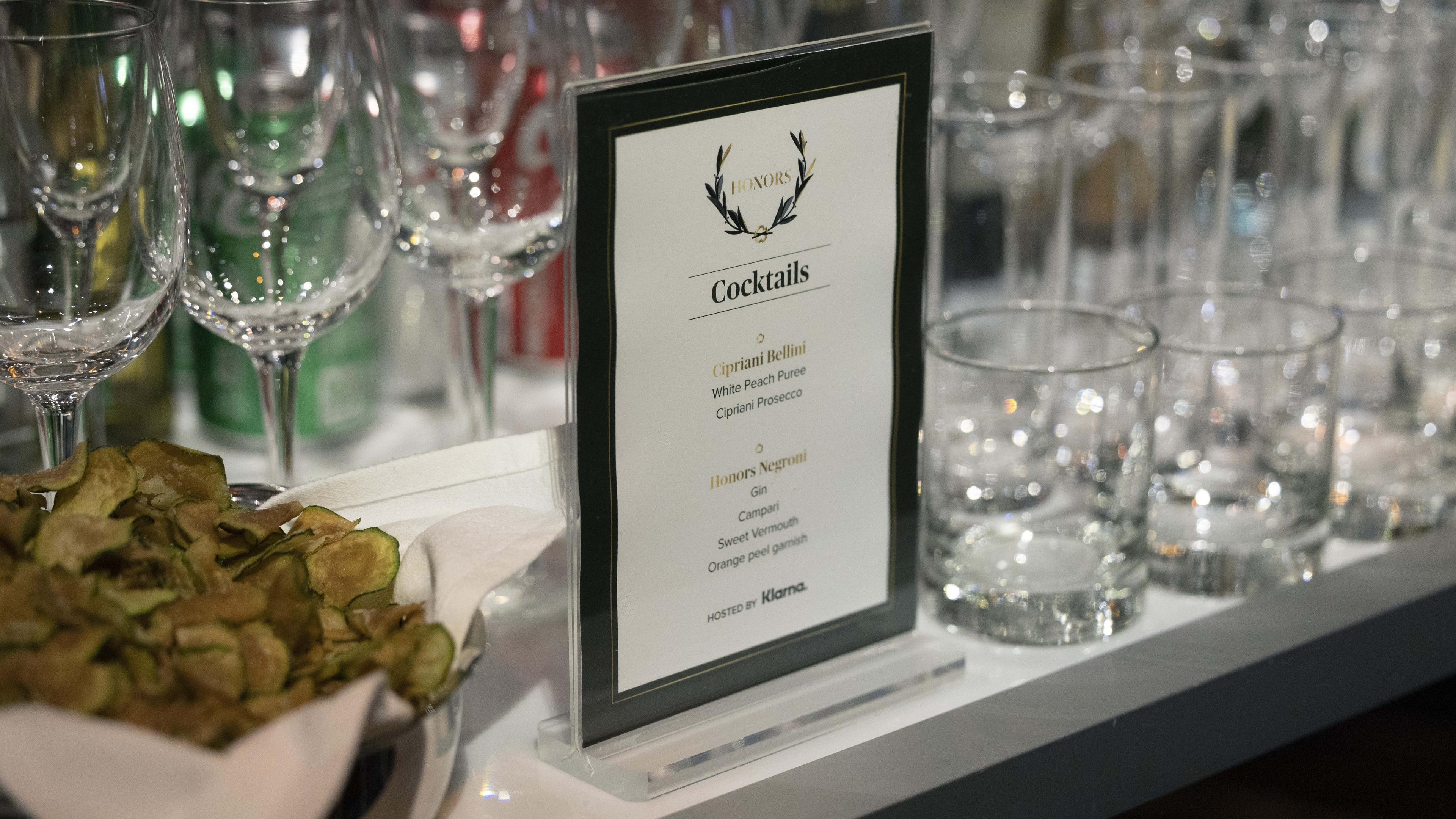 WWD Honors cocktail menu kept on the bar amidst glasses