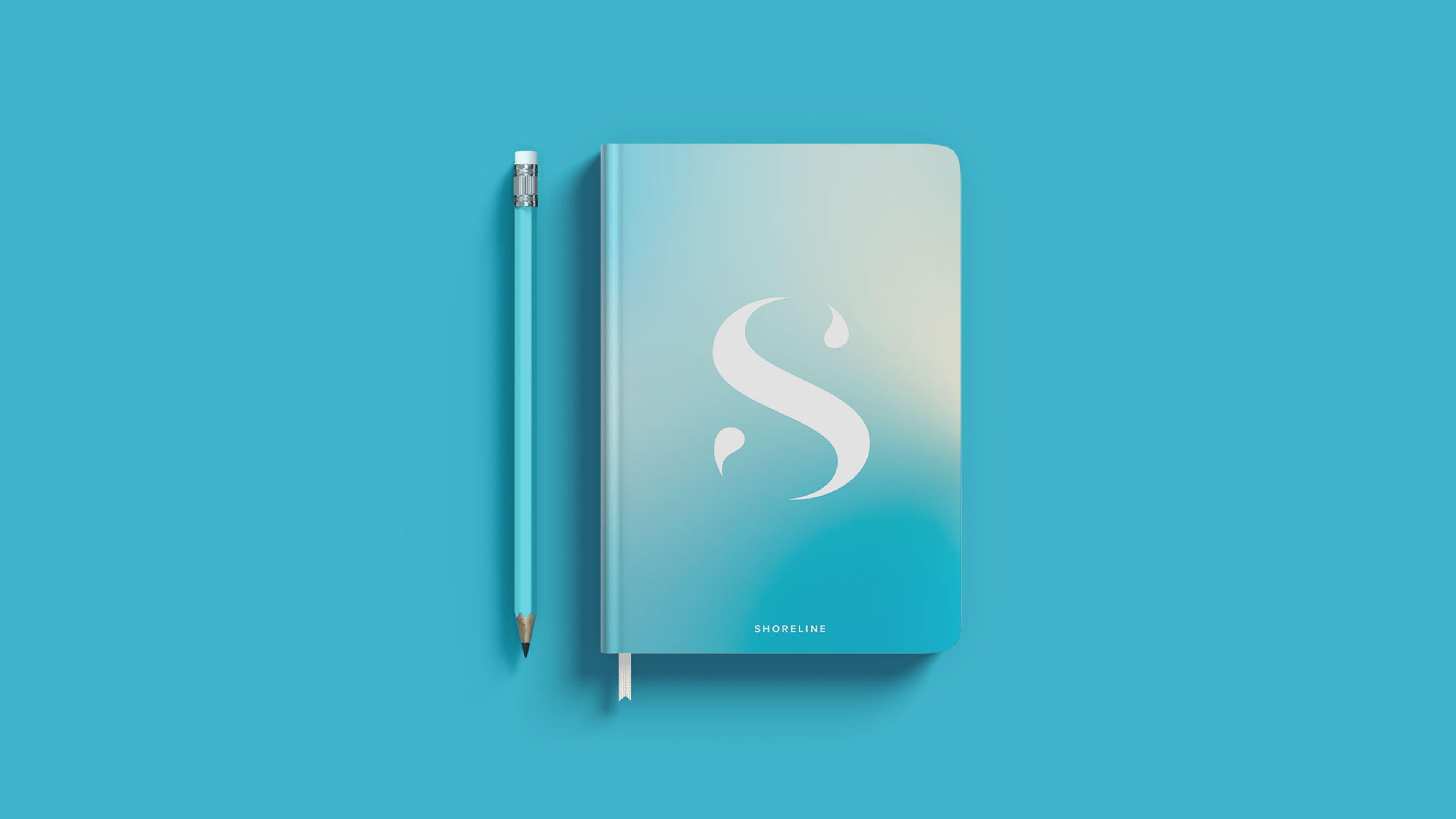 ShoreLine branding on a blue notebook with a blue pencil next to it