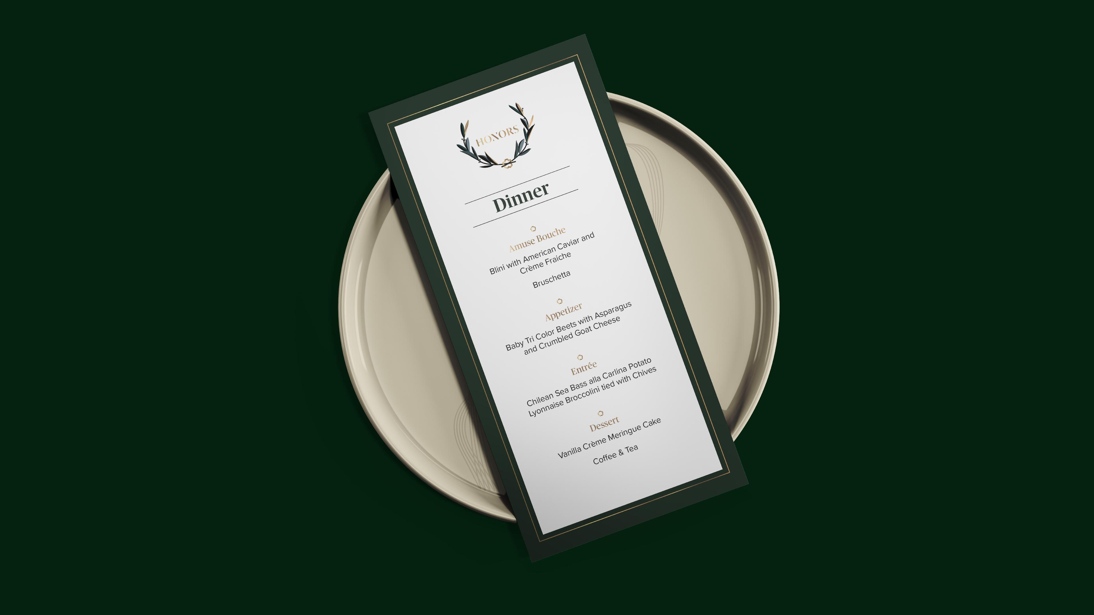 WWD Honors branding on a dinner menu kept on a gold plate
