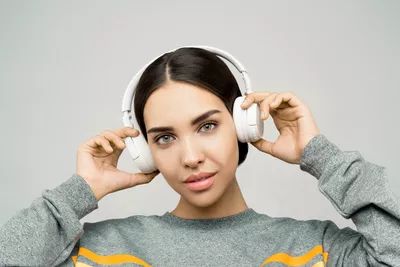 mulher ouvindo musica headphone branco fundo cinza