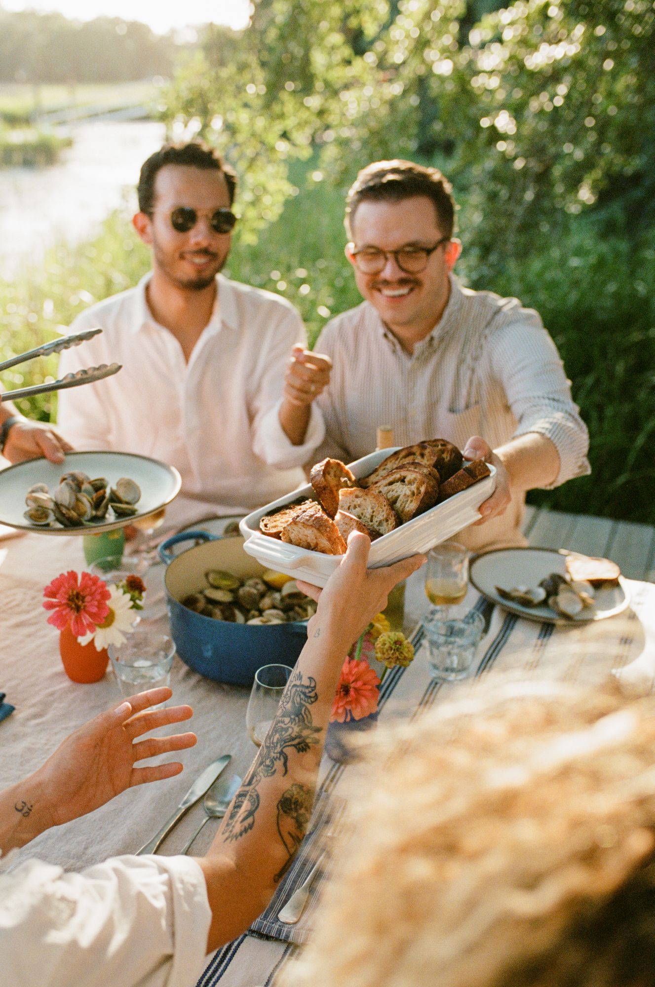 Friends gathered around an outdoor dinner table sharing a meal together