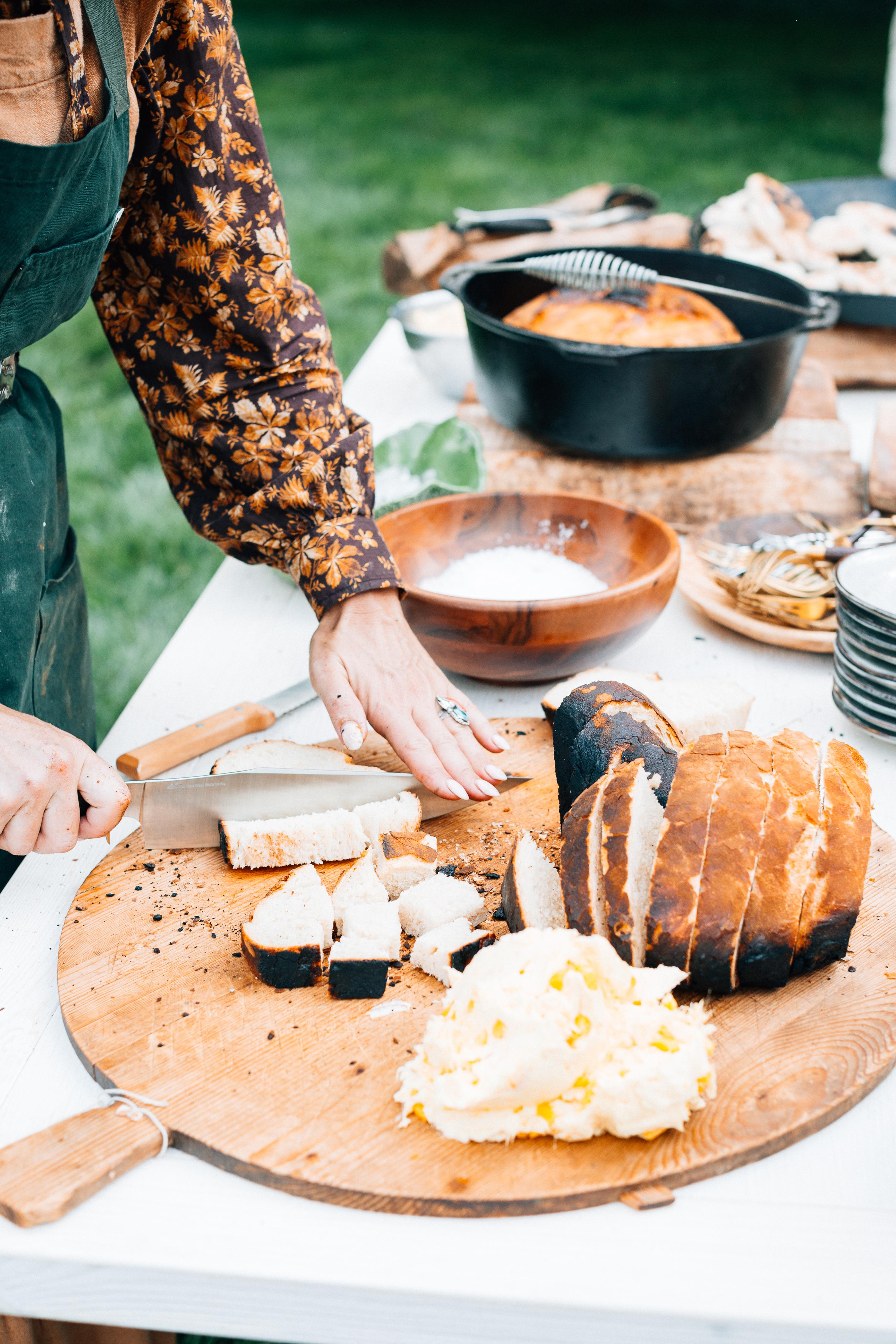 Sarah Glover cutting cheese and bread for a privat event.