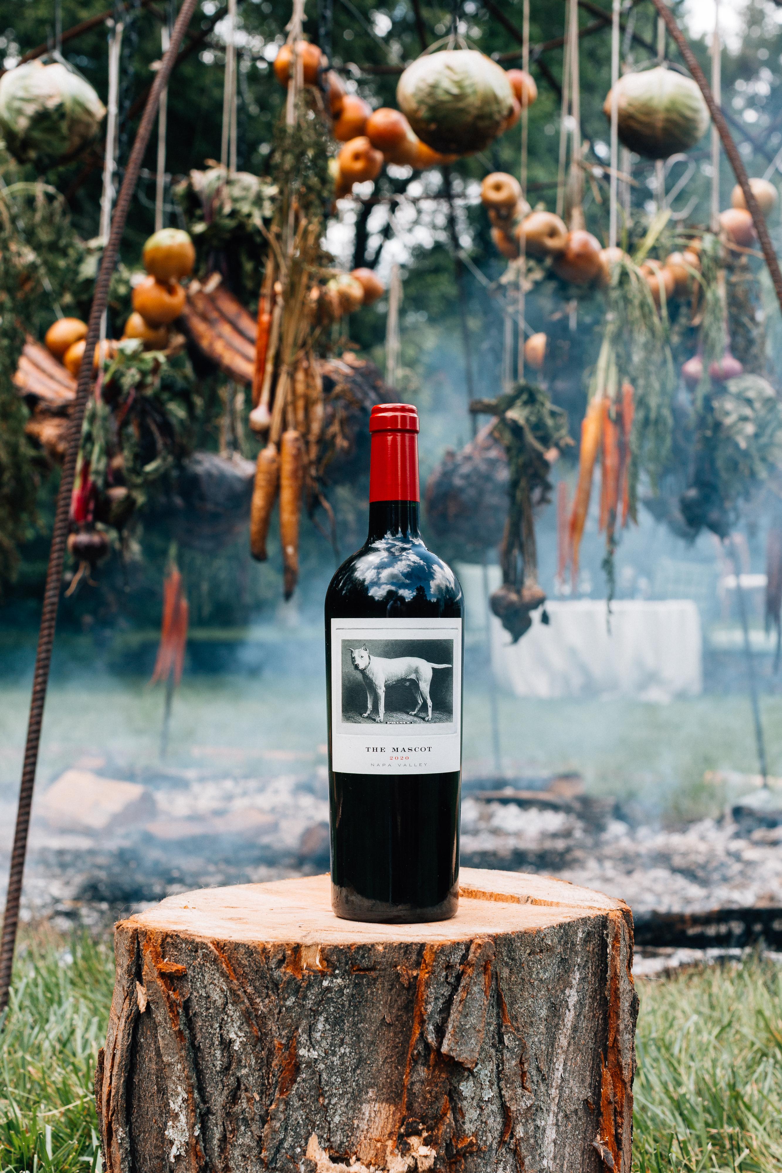 The Mascot wine next to food cooking on an open fire.