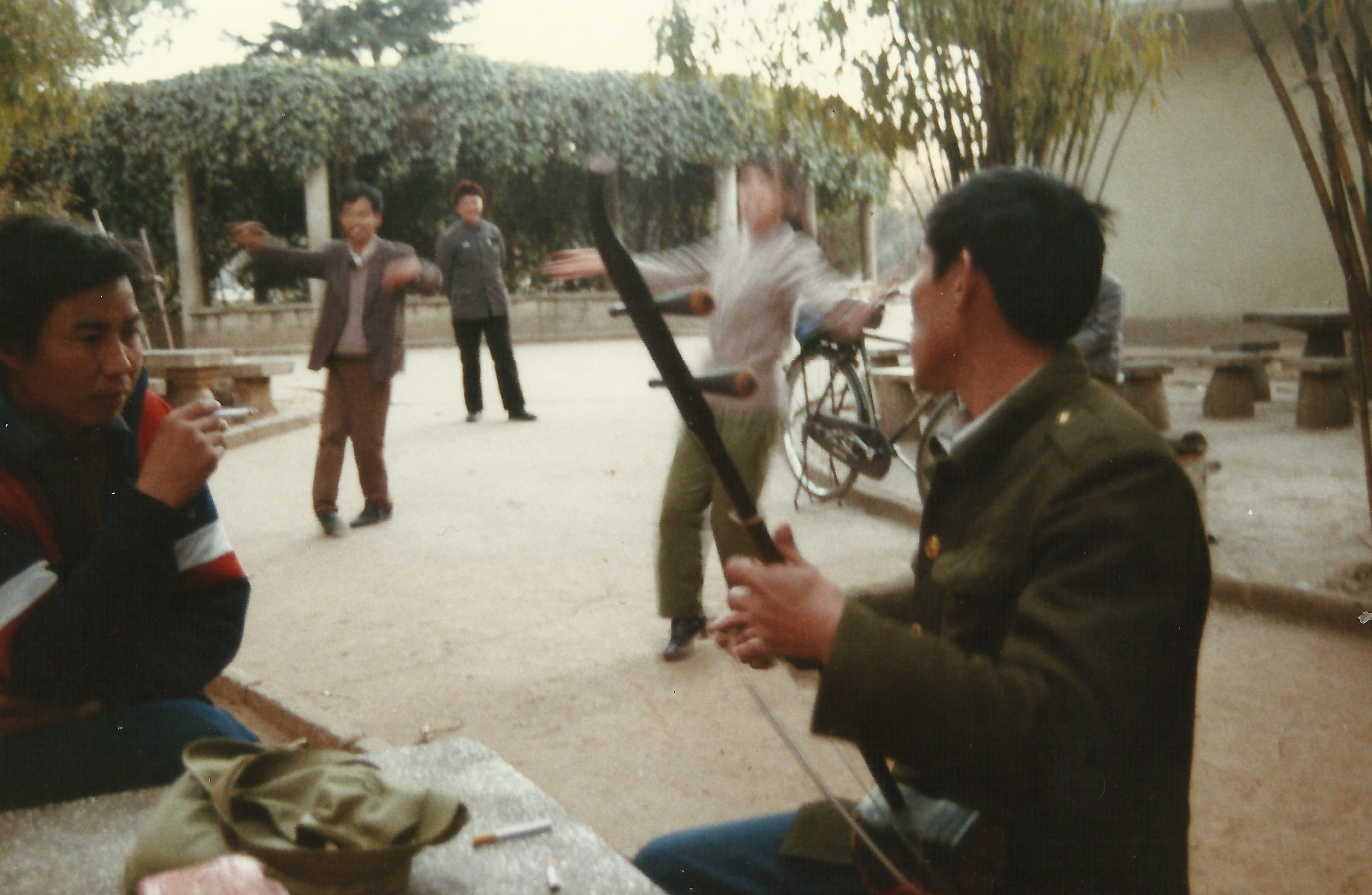 Kunming. Erhu player with people dancing in the background.