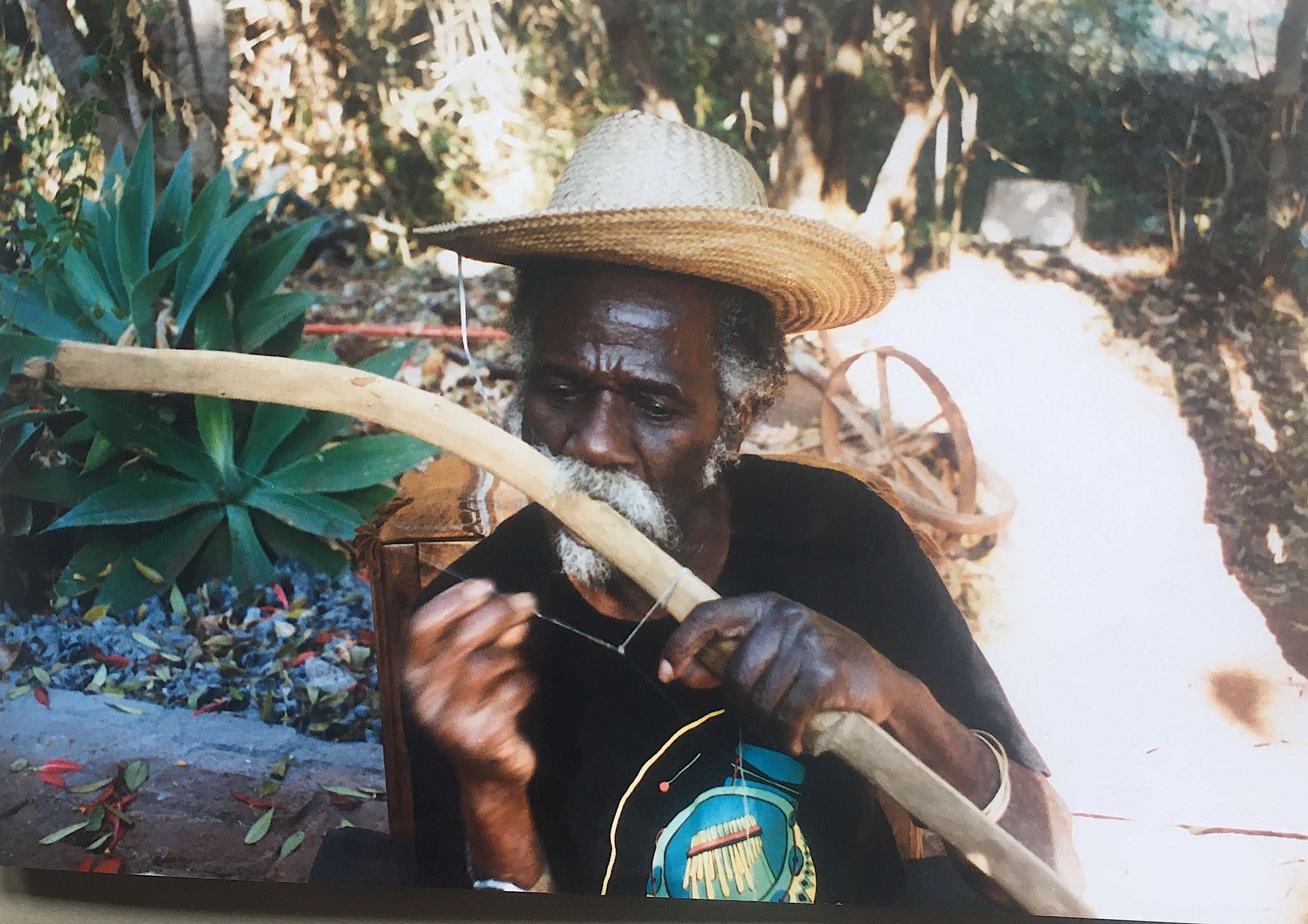 Frank Gombo musician playing ancient mouth bow the Chippendani in Zimbabwe. He was a baker and made his instruments. Frank was from Mozambique.