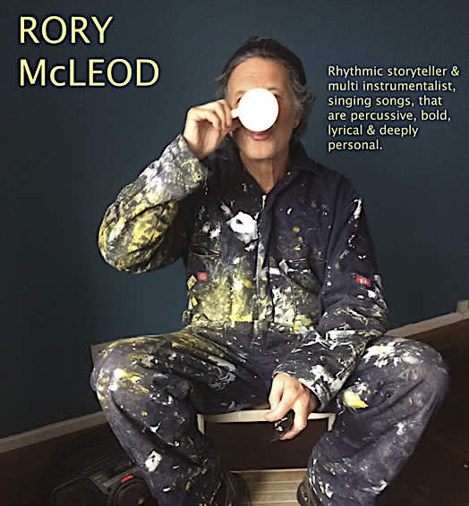 Rory in painting overalls drinking a mug of tea.