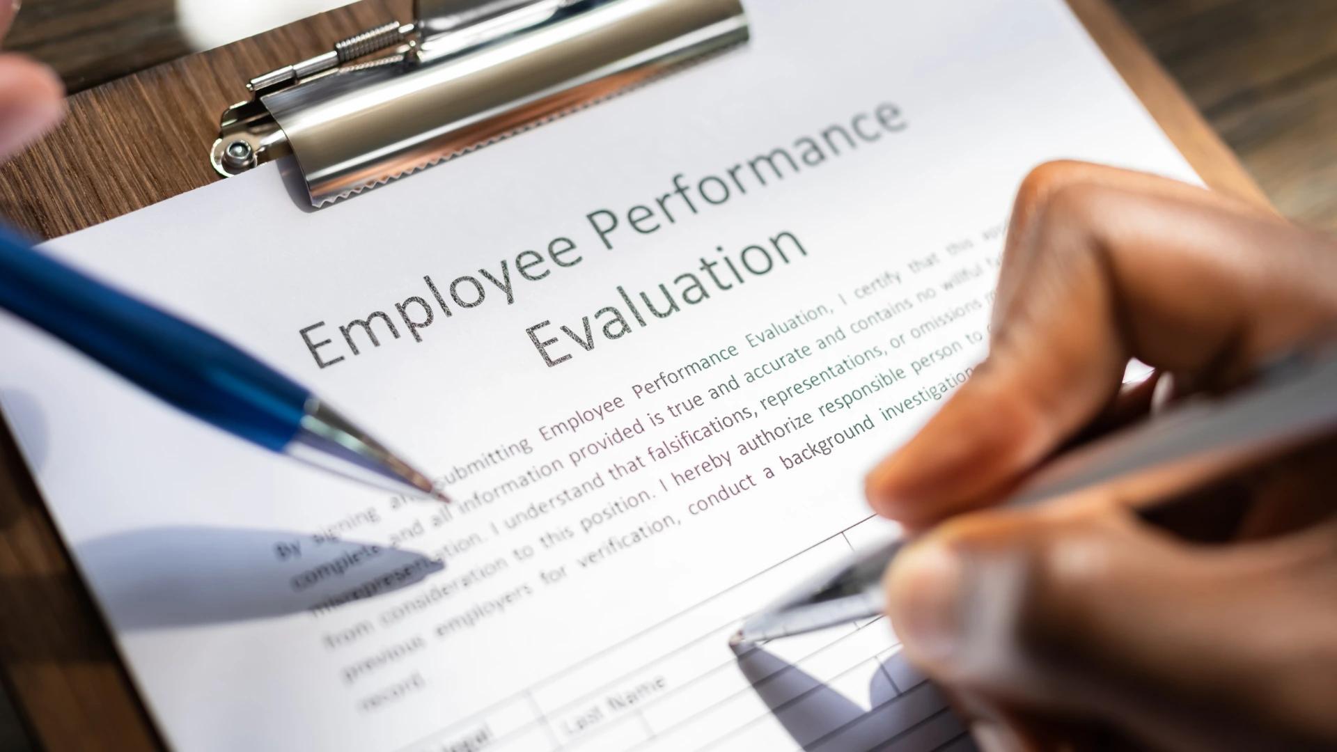 Close-up of a person filling out an Employee Performance Evaluation form, highlighting assessment and feedback processes for AI development teams at https://codeautomation.ai/
