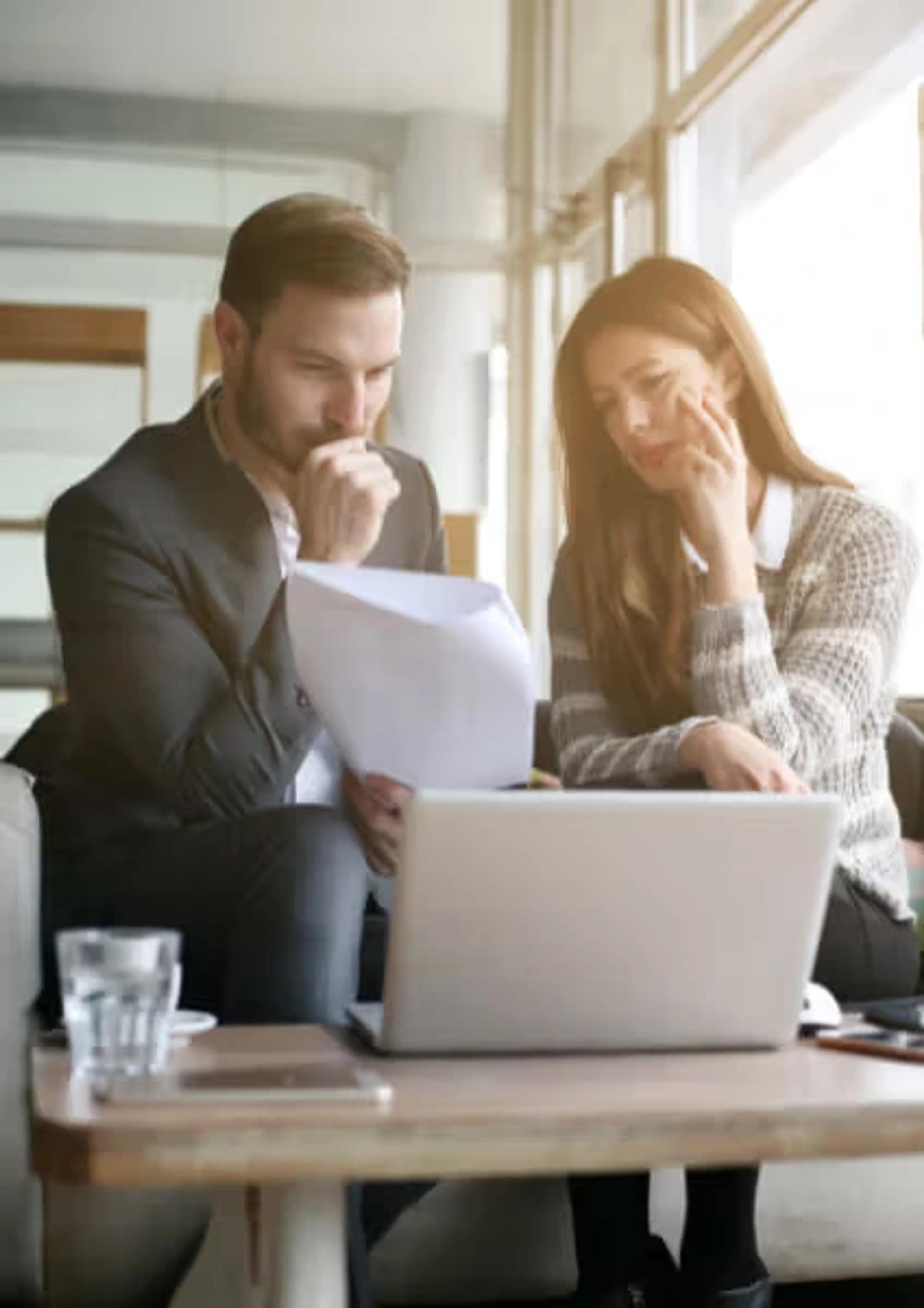 Business professionals reviewing documents and collaborating on GHL CRM customization and automation strategies at CodeAutomation.ai, US-based software company for business automation, CRM customizations, and AI agent development
