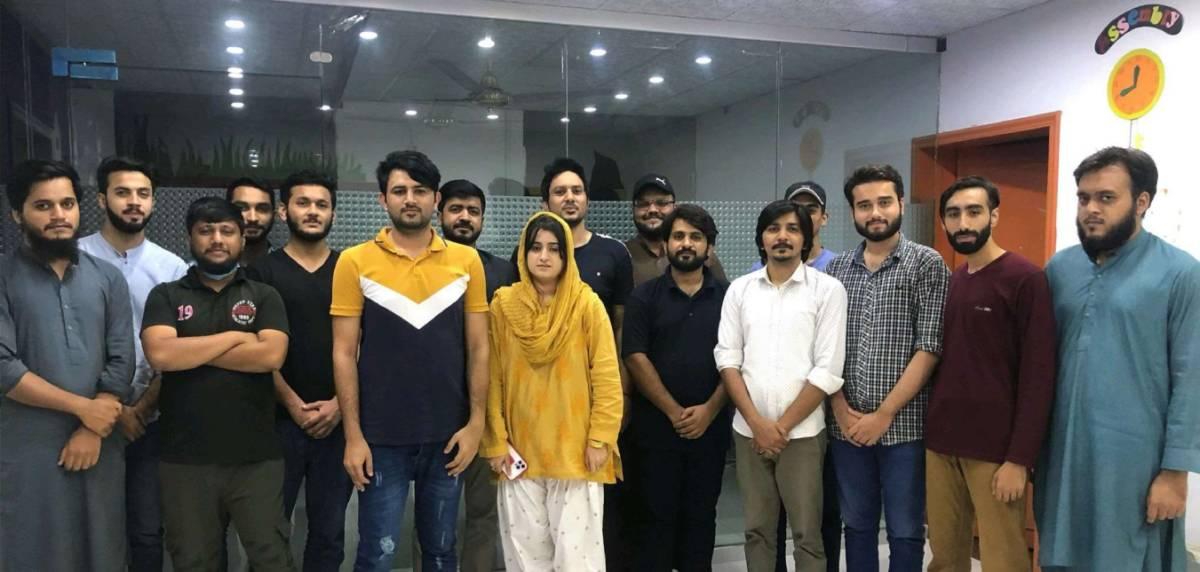 Team Lead Farhan Ghaffar with CodeAutomation’s Pakistan Chapter employees in a group photo, showcasing a collaborative work culture.