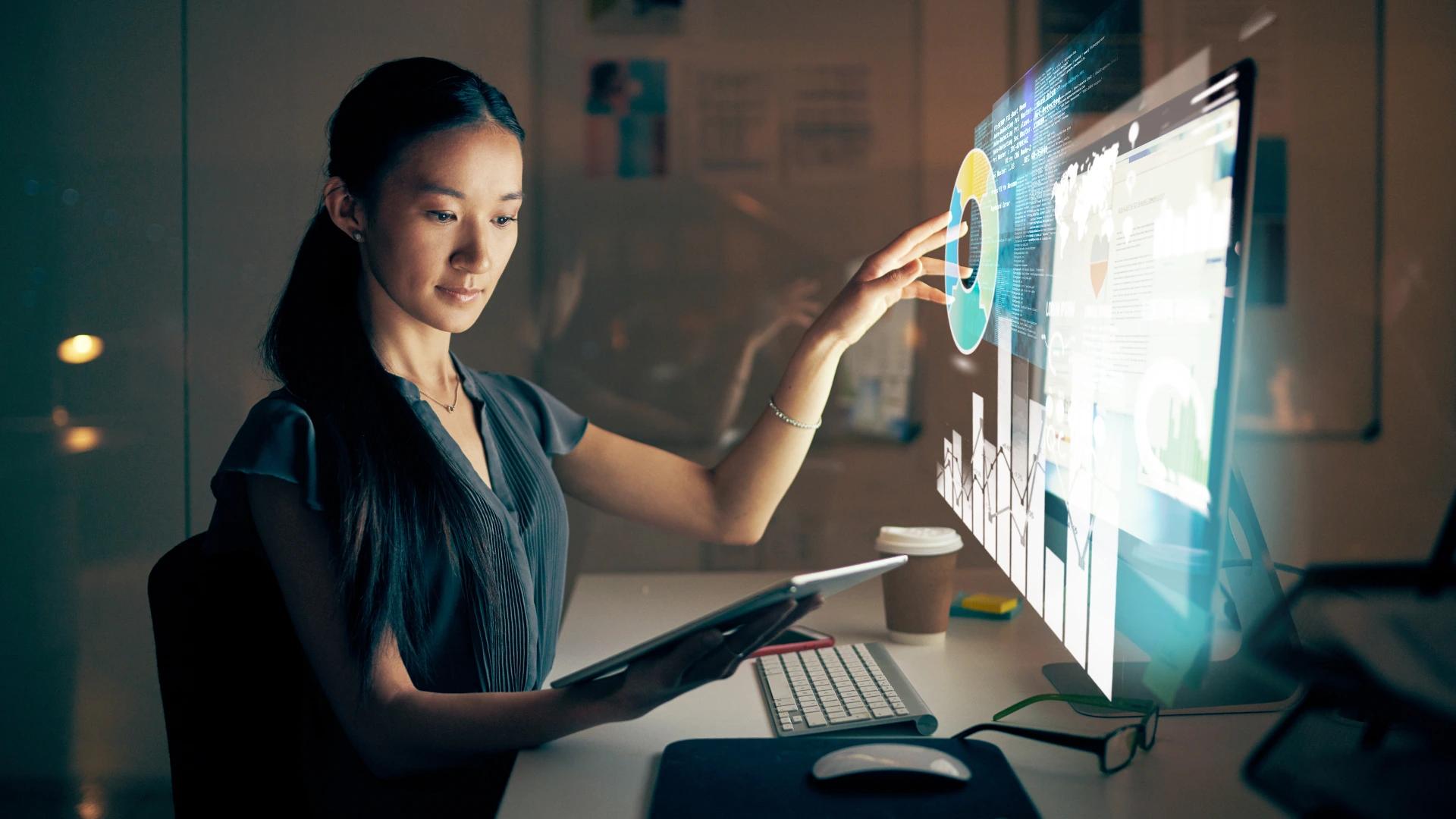 Professional woman interacting with a holographic data visualization on a screen, showcasing advanced technology and AI-driven analytics at https://codeautomation.ai/