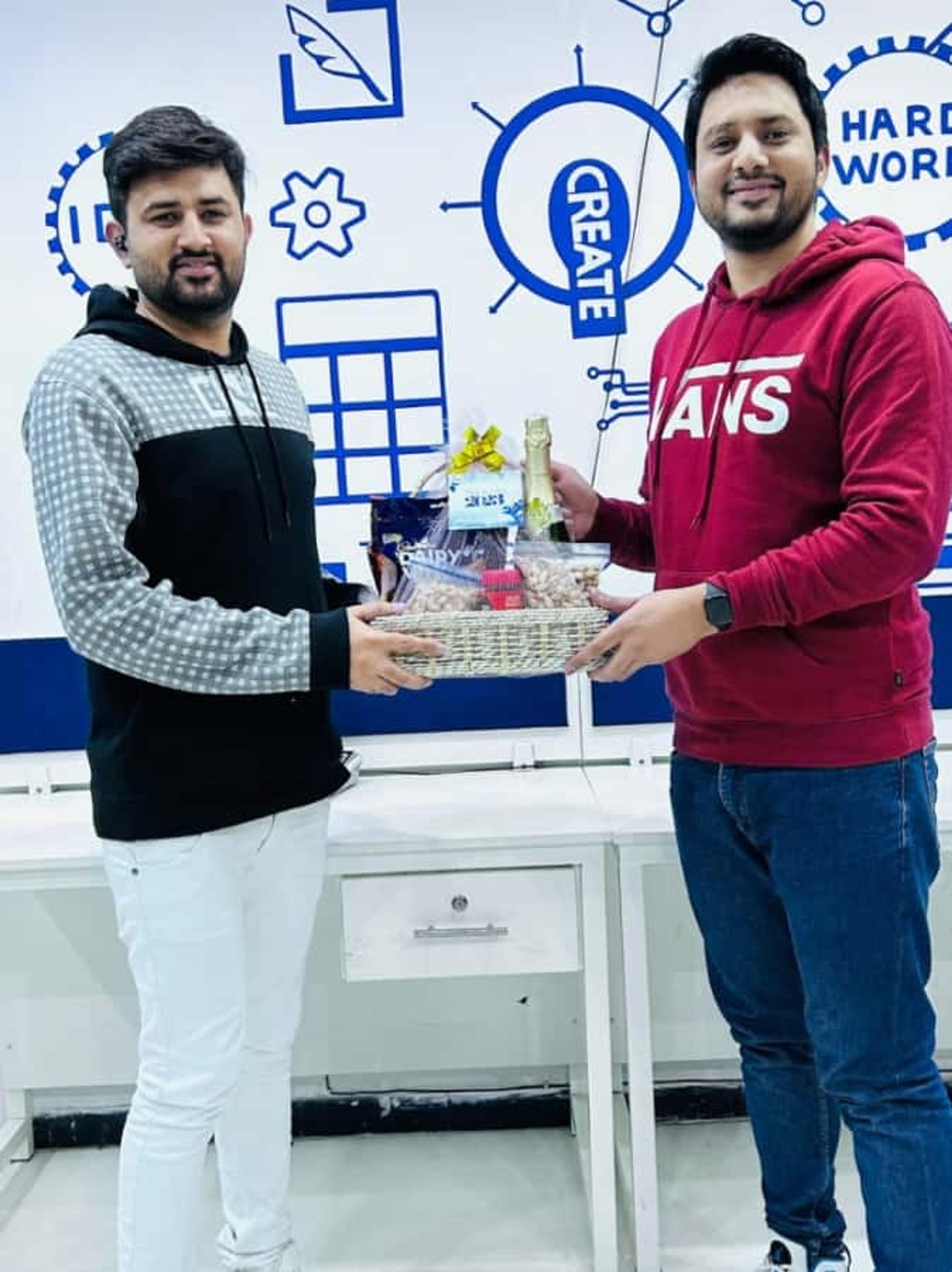 CodeAutomation CEO Adnan Ghaffar handing a gift basket to an employee during a company celebration, showcasing a vibrant Life at CodeAutomation culture.